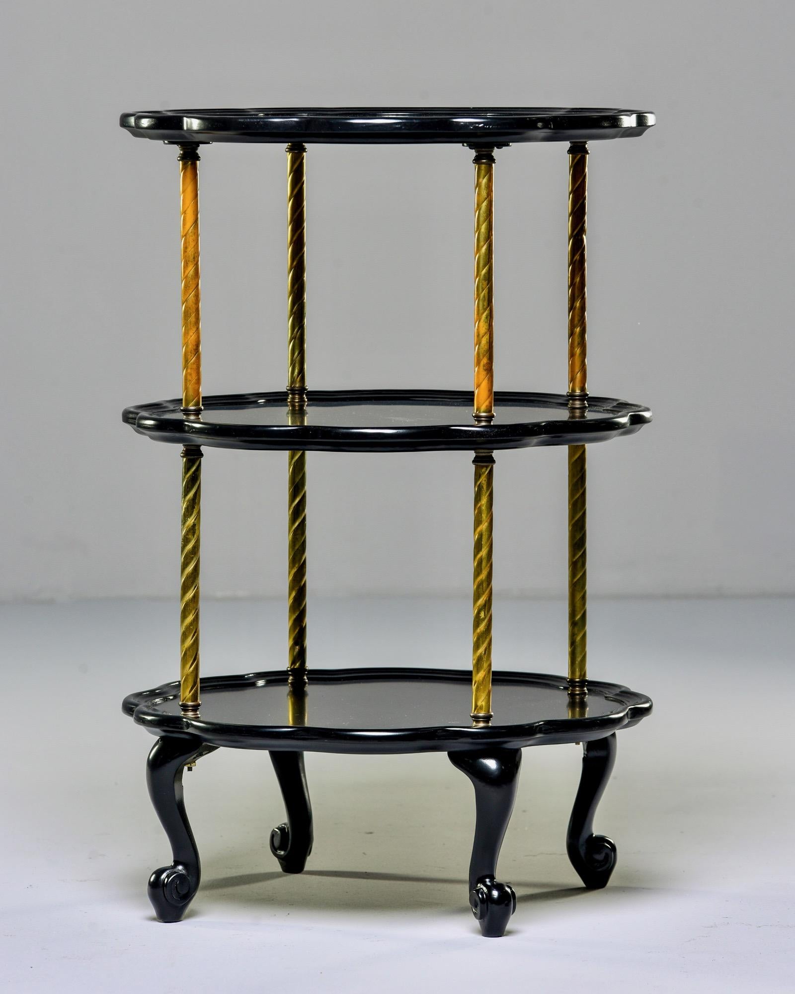 French side table has three oval tiers with curved feet, brass supports and new ebonized finish, circa 1910. Unknown maker.