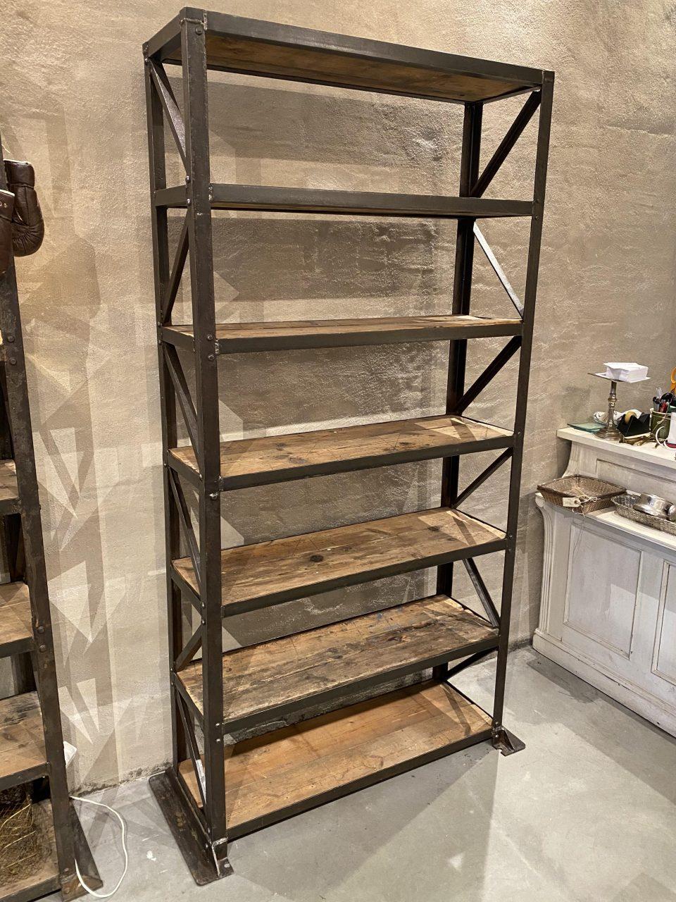 Raw and rustic man-high vintage French industrial shelf unit /bookcase. Originates from a now closed French warehouse, dating from the beginning of the last century. Appears as a sculptural dark iron frame solid quality structure, and divided into 7