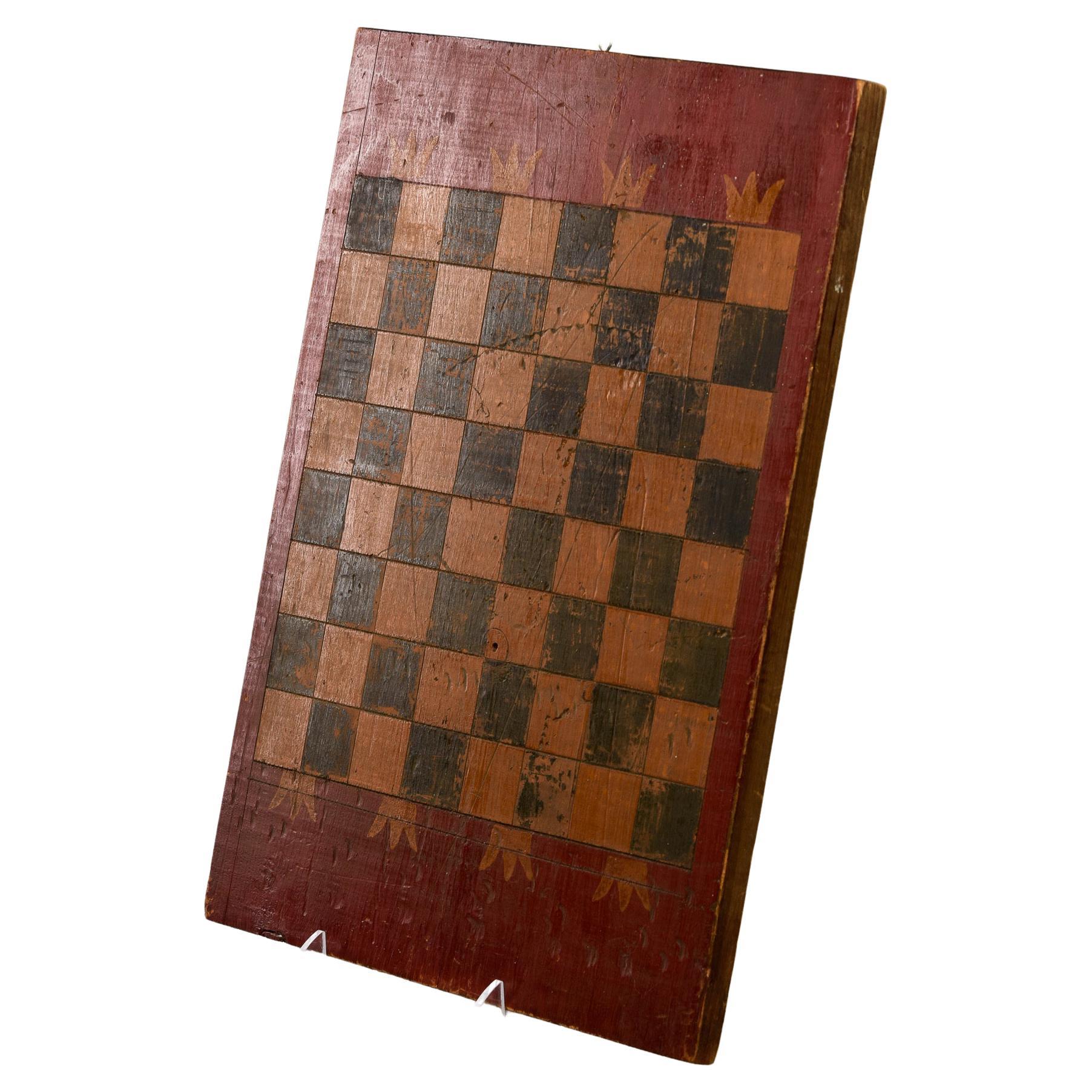 Circa 1900 hand painted game board found in England. Red edges with gold crown motif and black and gold squares. Makes a great wall piece. Unknown maker.