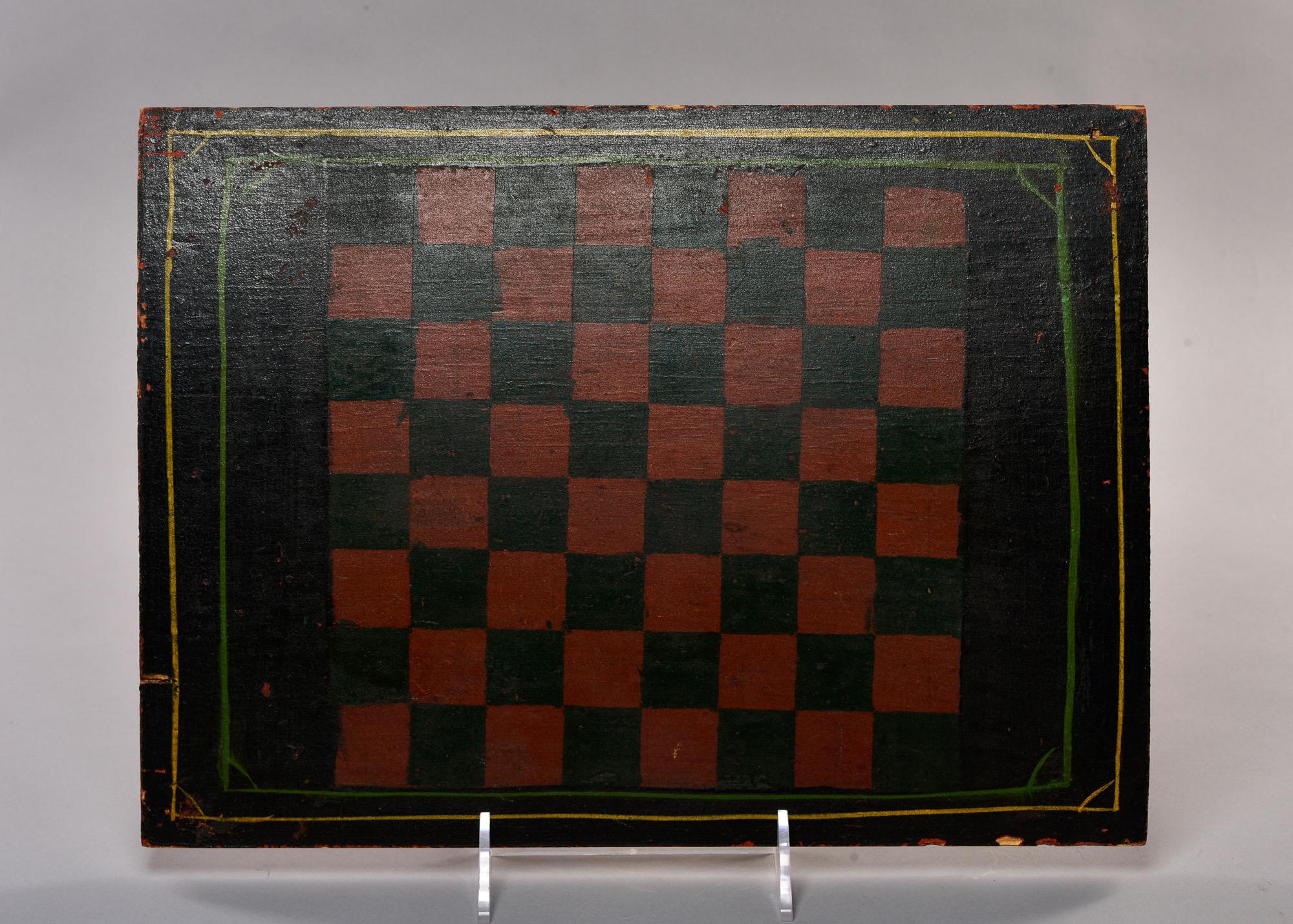 Found in England, this circa 1900 hand painted checker board with black and red squares and thin yellow and green outline at the outer border. Board is slightly bowed with age.