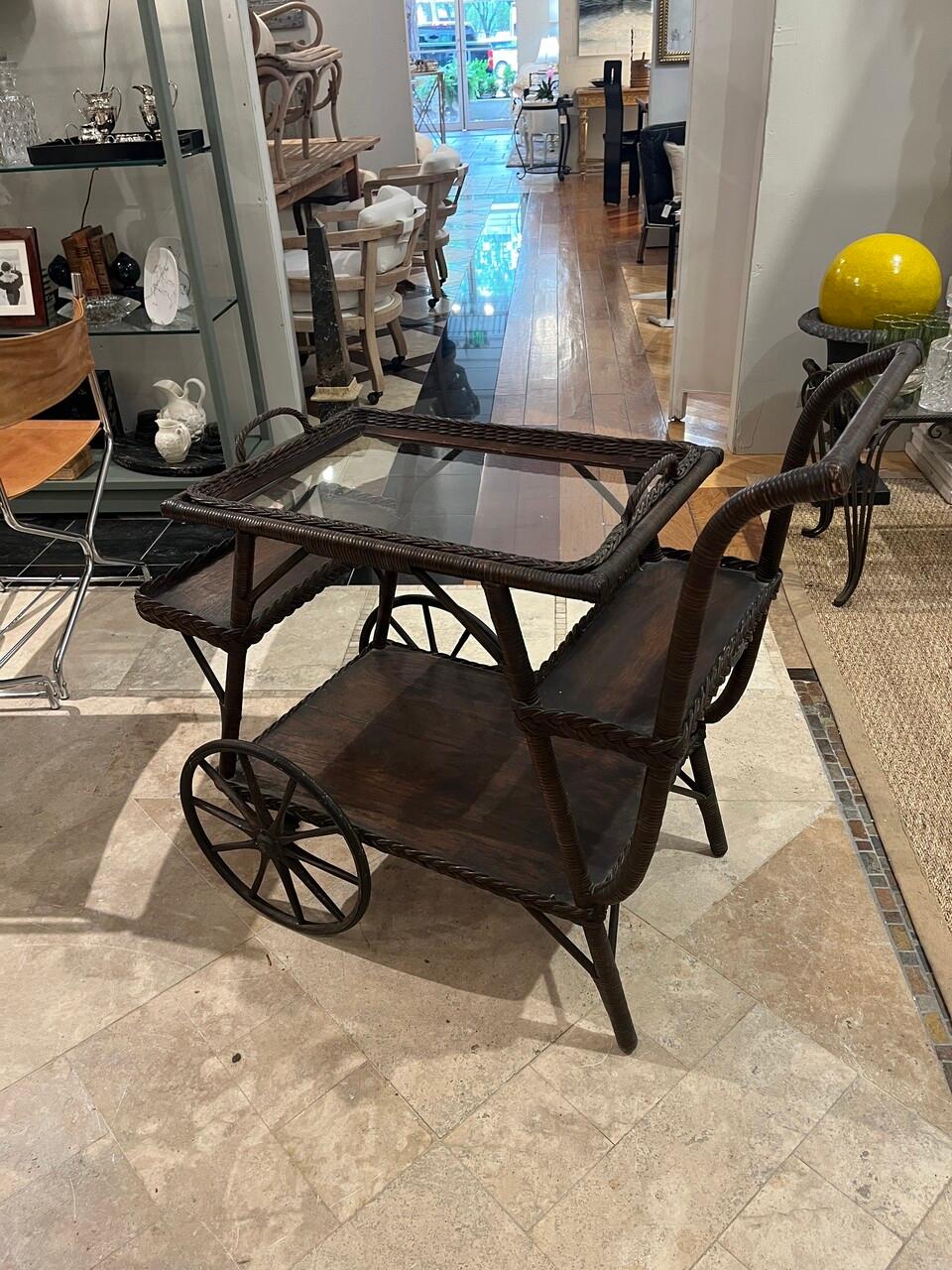 Transport yourself to the elegant gatherings of the early 20th century with this exquisite Heywood Wakefield wicker bar/tea cart. Crafted with timeless sophistication, it features intricate wicker weaving and a removable serving tray, combining