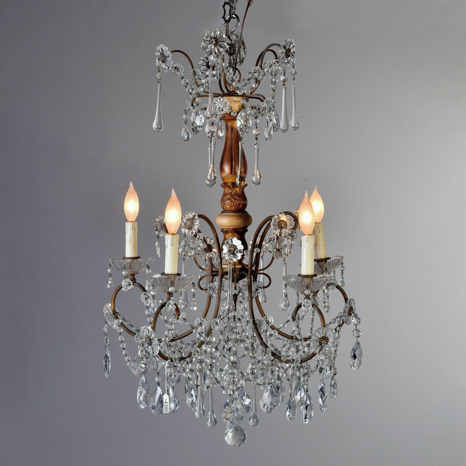 Italian crystal chandelier with gilded wood center support has five candle style lights and crystal flowers, long drops, beaded swag and faceted pendants, circa 1920s. New wiring for US electrical standards.

Candelabra sized sockets.
  