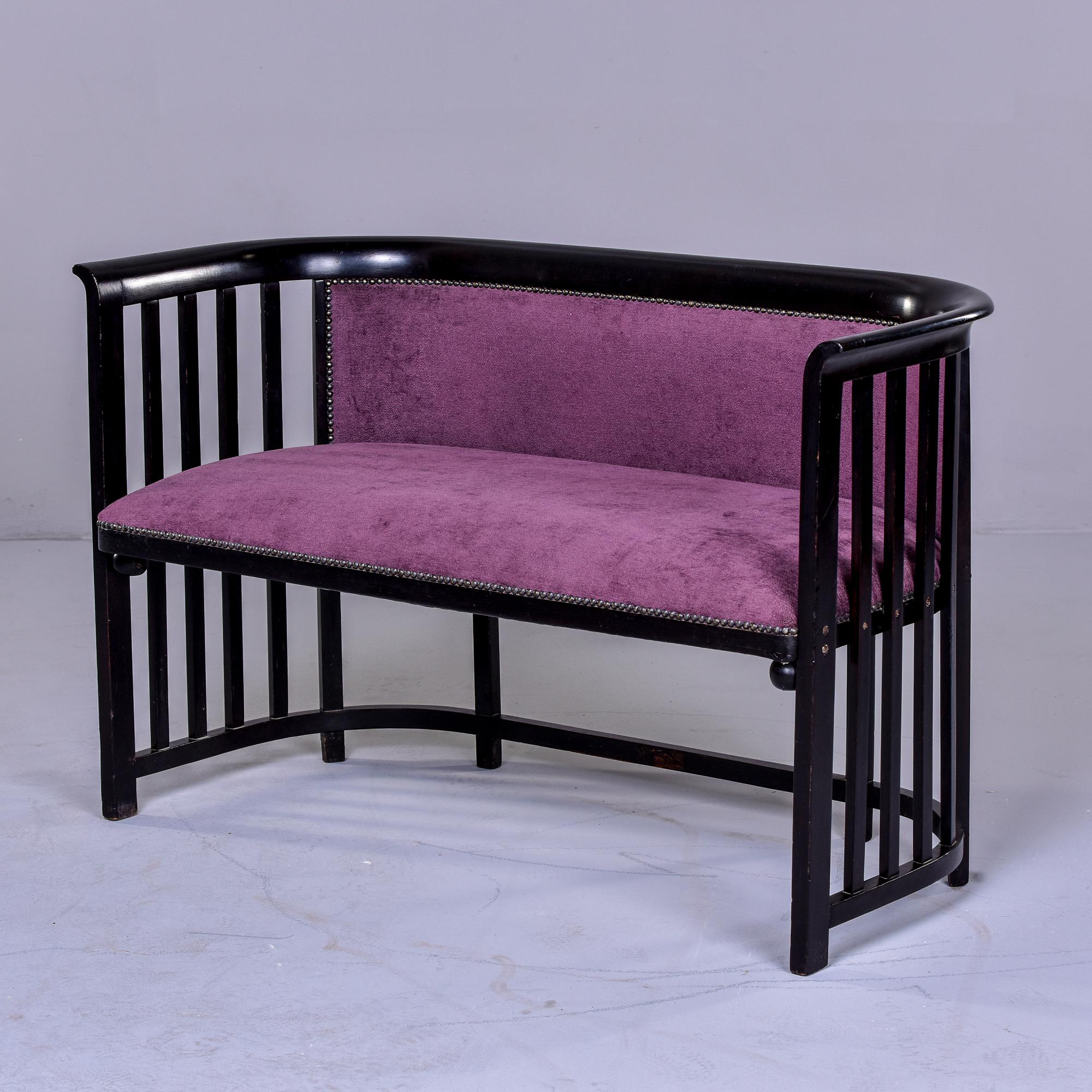 Circa 1910s classic settee designed by Josef Hoffmann. We believe this was manufactured by Austrian manufacturer Jacob & Josef Kohn but have no found markings. Slatted sides and black stained bent beech. This piece was reupholstered in a plum