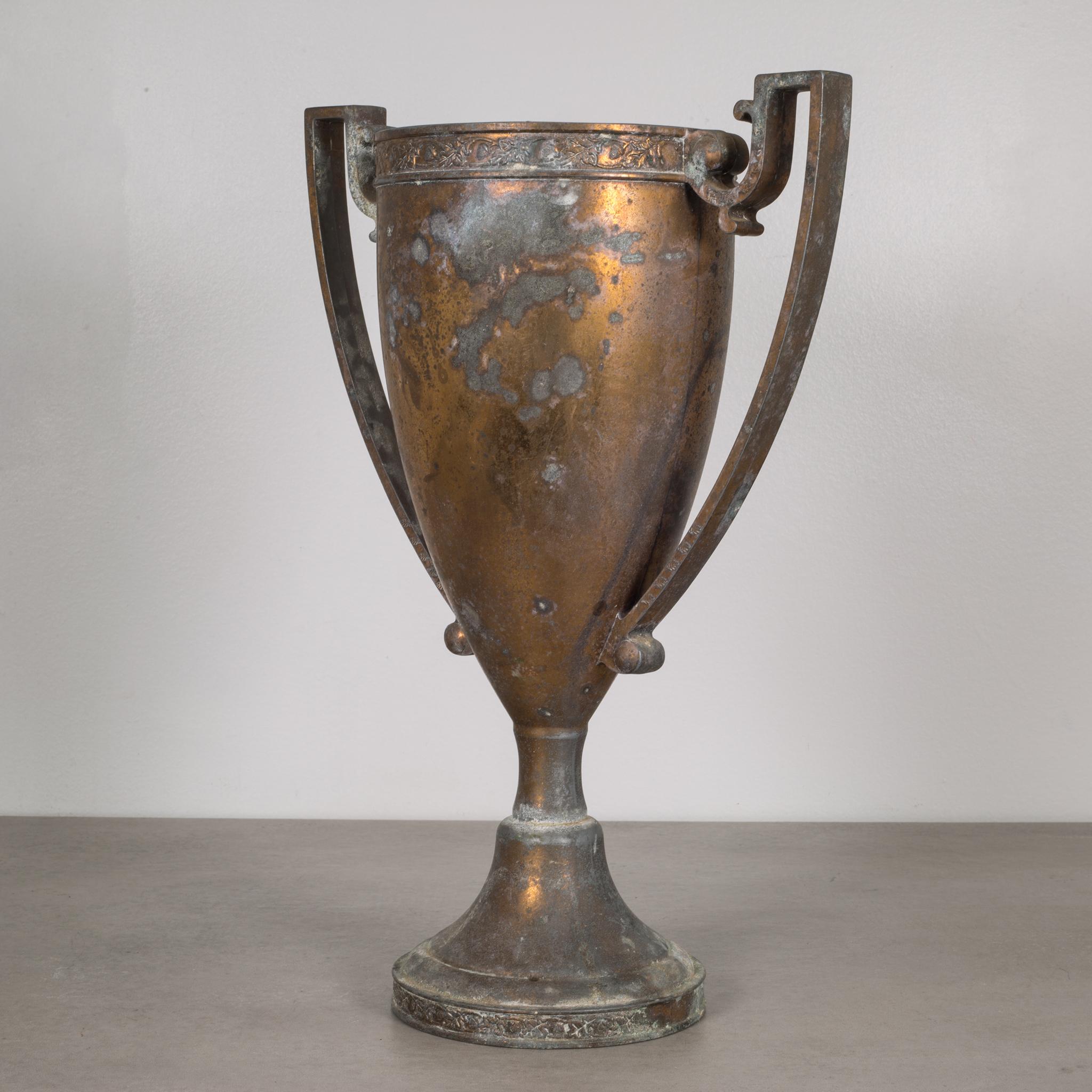About

This is an original solid bronze loving cup trophy marked Dodge Inc. on the bottom. The distressed trophy has decorative leaves on the top, bottom and arms. The heavily patinated trophy has retained some of its original color with minor