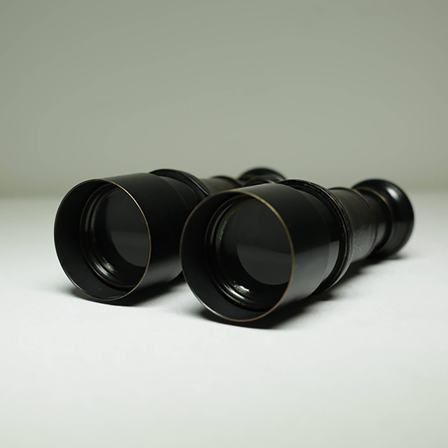 Leather wrapped brass binoculars with telescoping lens to prevent glare. Stamped 