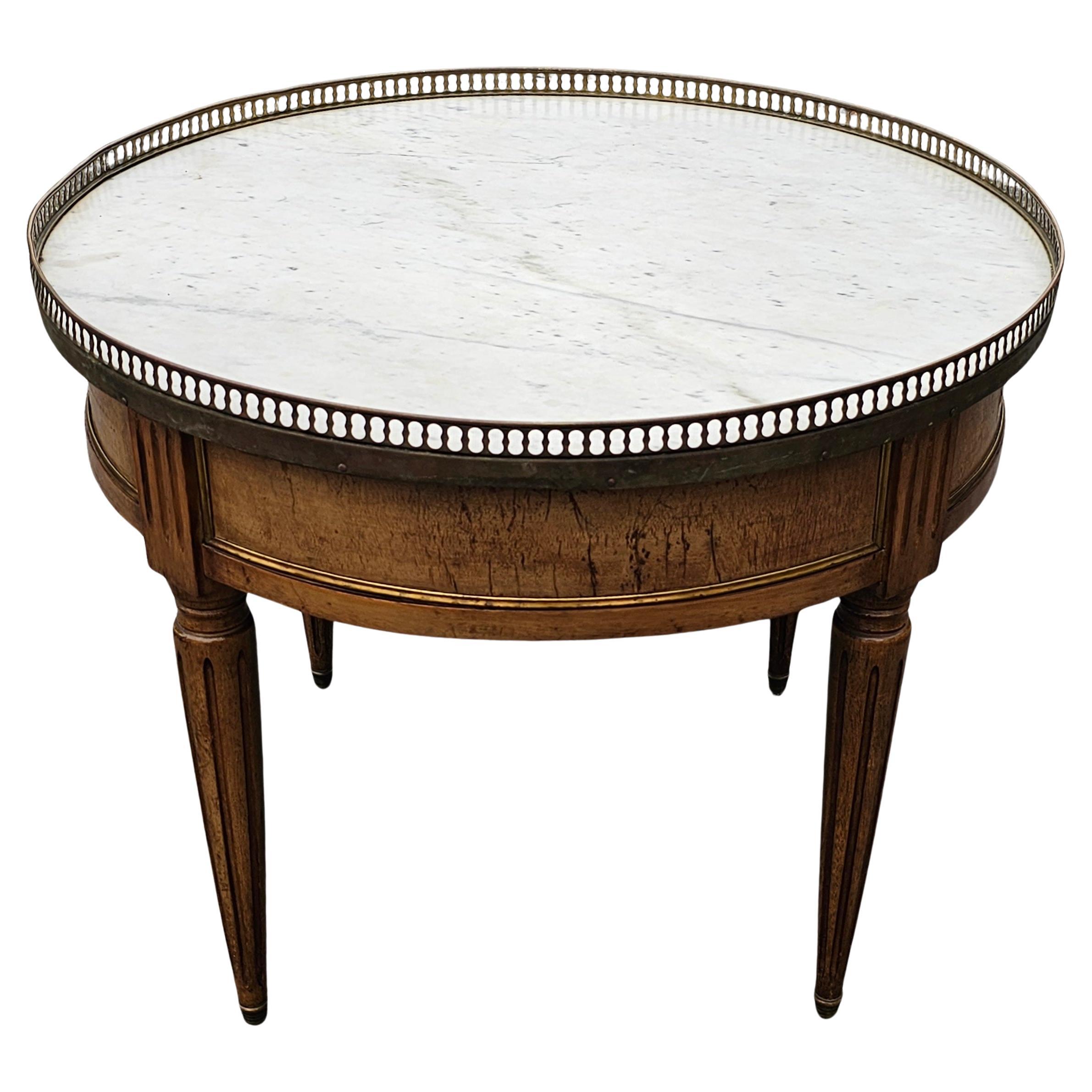 Tavolo Bouillotte Gueridon in noce e marmo con piano gallerizzato dei primi anni del XX secolo.