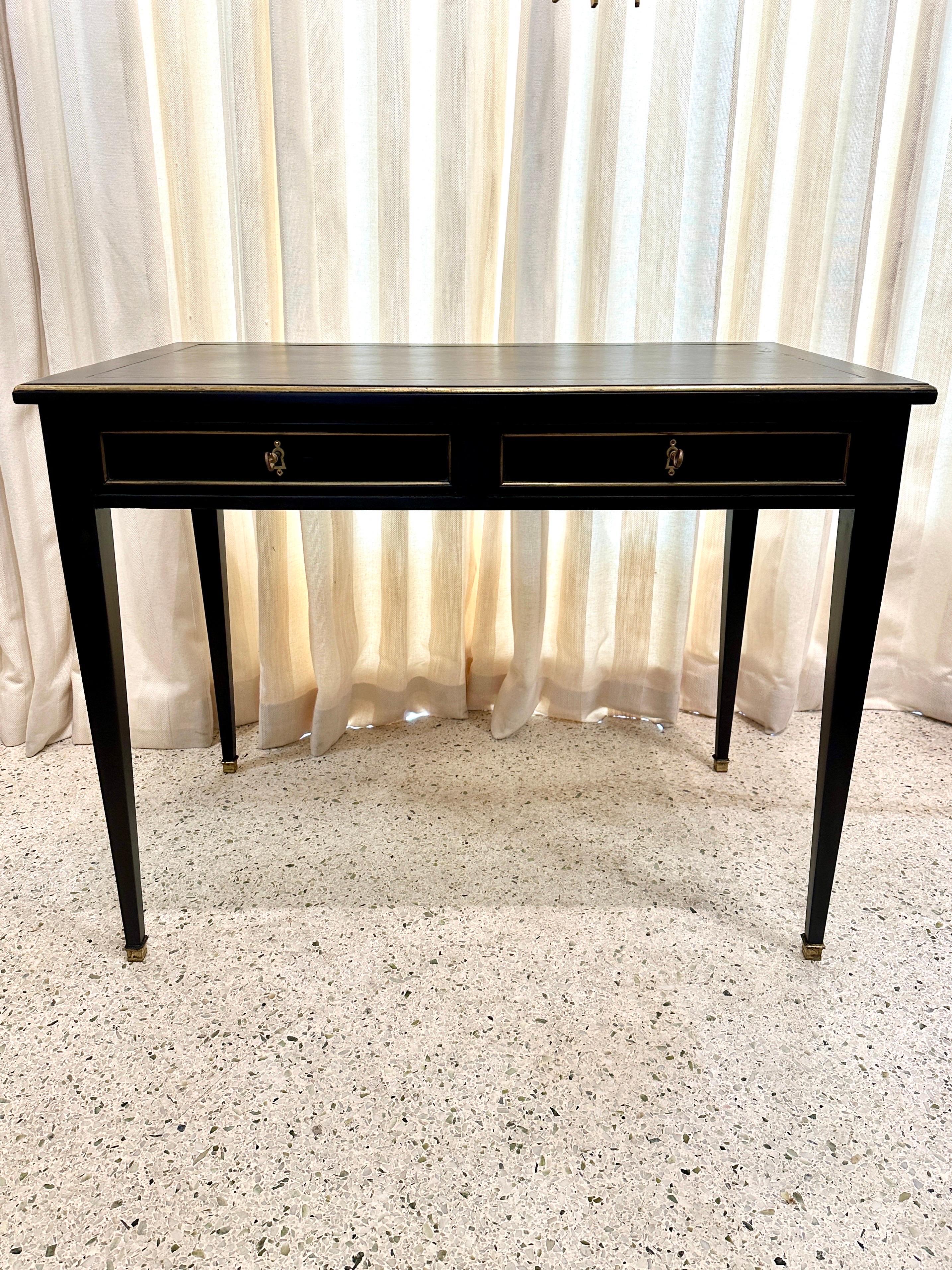 A wonderful early 20th Century French Louis XVI style writing desk in ebonized black finish.  Dating to around the 1940’s with original brass mounts and leather top.  This is the epitome of elegance and sophistication - the Antique French Louis XVI