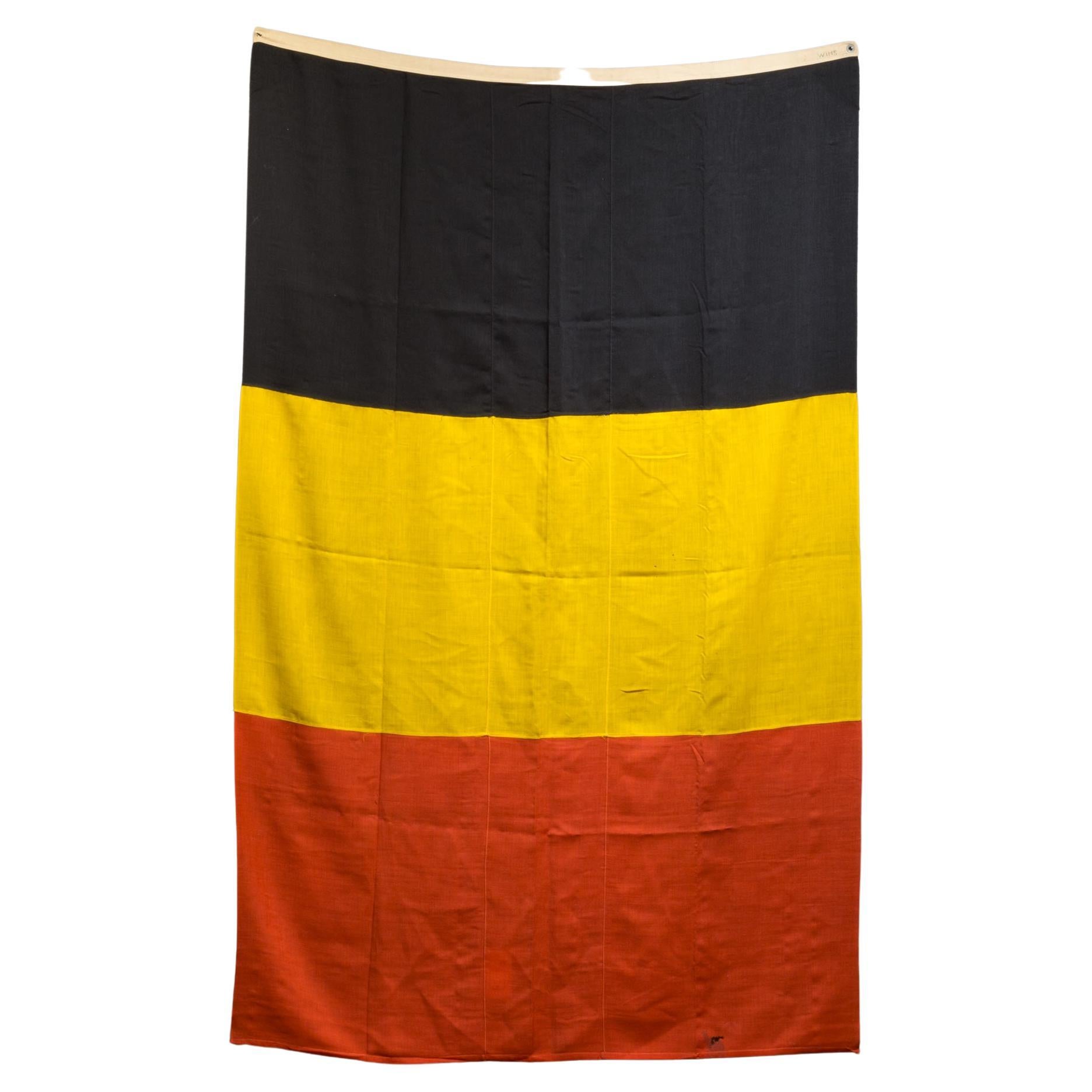 ABOUT

An original monumental Belgian flag.

    CREATOR Unknown.
    DATE OF MANUFACTURE c.1940-1950.
    MATERIALS AND TECHNIQUES Wool, Metal.
    CONDITION Good. Wear consistent with age and use. One grommet is missing.
    DIMENSIONS H 8 ft. W 5