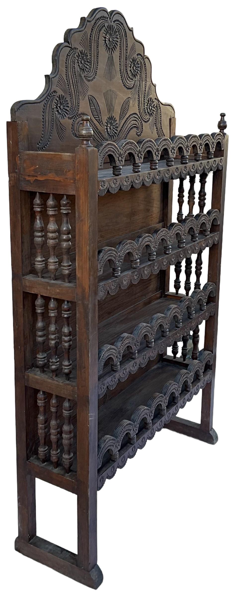 This is an early heavily carved Moroccan etagere / shelving unit. The pierced swags and turned supports adorning each shelf really elevate the look. There is roughly 12 inches between each shelf. This could work in a variety of spaces from kitchen
