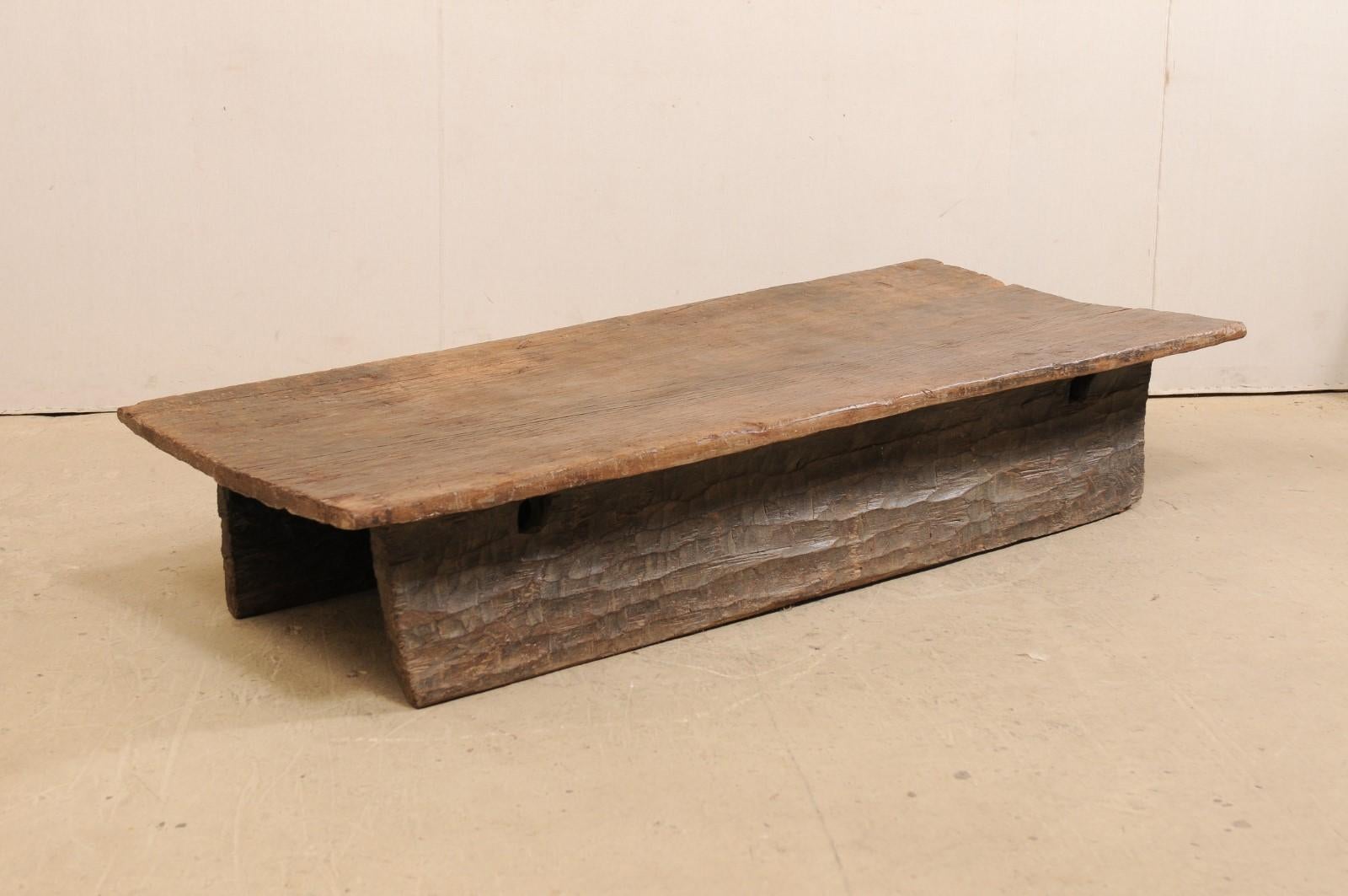 A Naga carved-wood table (or daybed) from the early 20th century. This antique coffee table would have originally been used as a wooden bed from the Naga tribes of Nagaland, North East India. This piece has been carved out of a single log! The