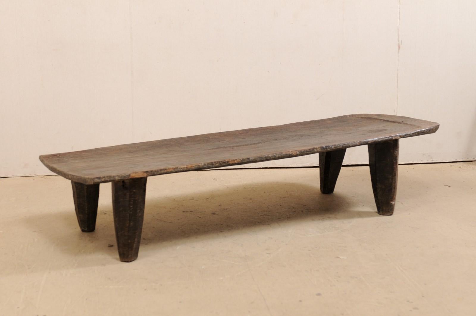 A hand-carved wood Naga coffee table from the early 20th century. This wooden bed from the Naga tribes of Nagaland, North East India has been carved out of a single log and would make for a great coffee table and conversational piece. Very nice