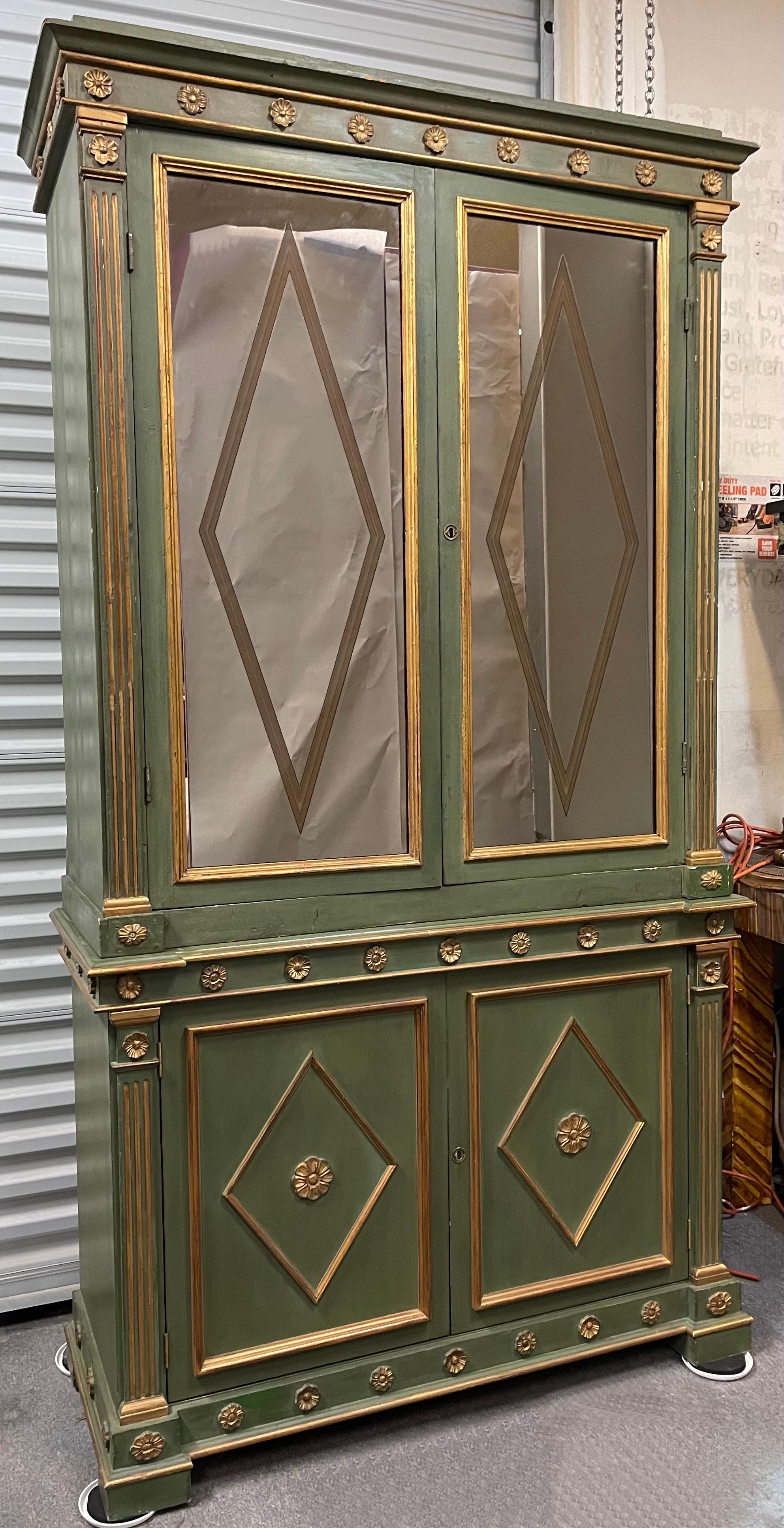 This is an early 20th century Venetian cabinet with neo-classical styling. The interior was mirrored later and had a stone bottom added to serve as a bar. The glass shelving is affixed. The bottom has one wood shelf that is adjustable.