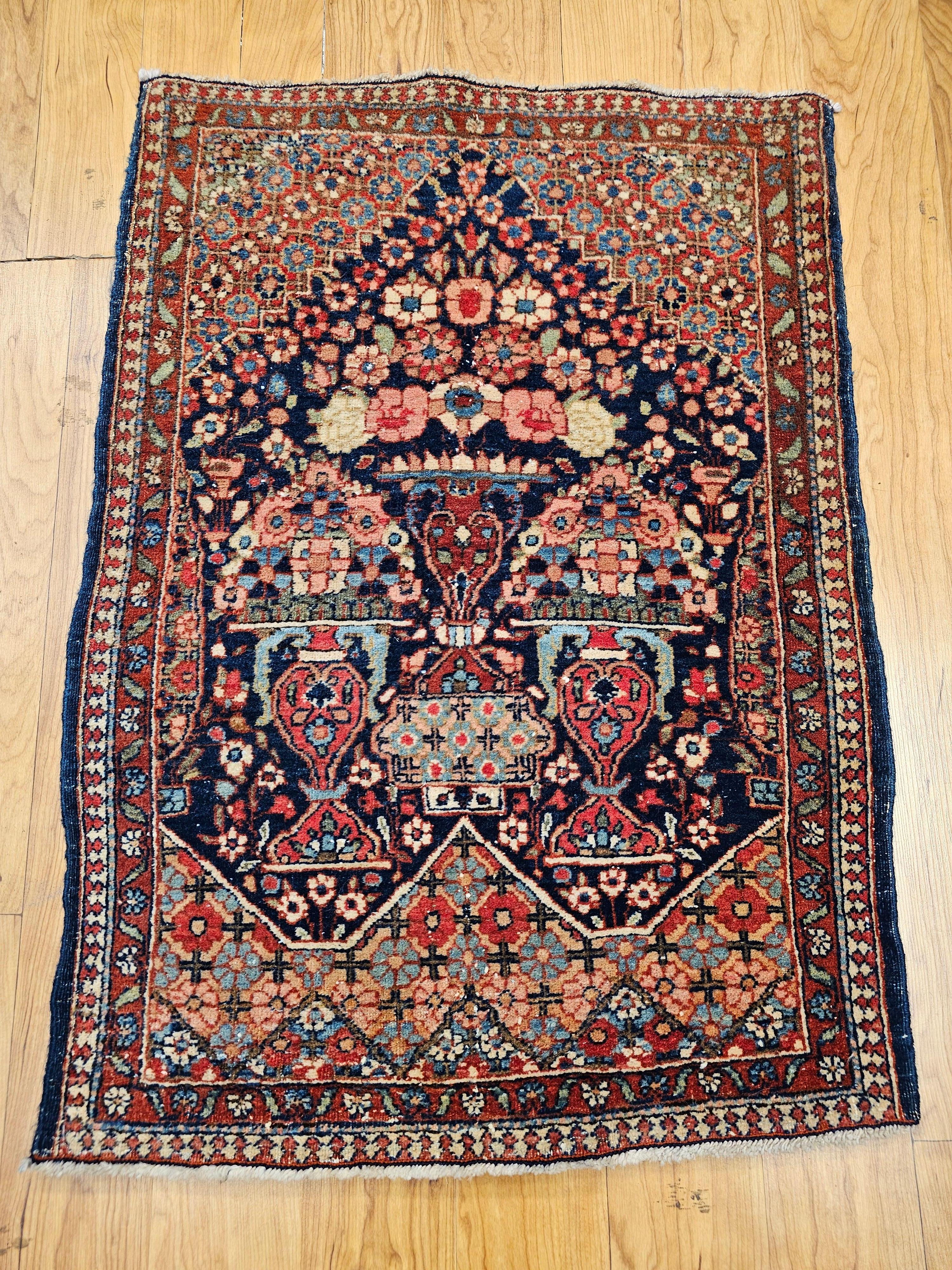 Un raro tappeto persiano Isfahan dell'inizio del XX secolo con un disegno pittorico a vaso su un ricco fondo blu e ornato da vivaci bouquet floreali. Questo piccolo gioiello della tessitura persiana è adatto sia come tappeto decorativo che come