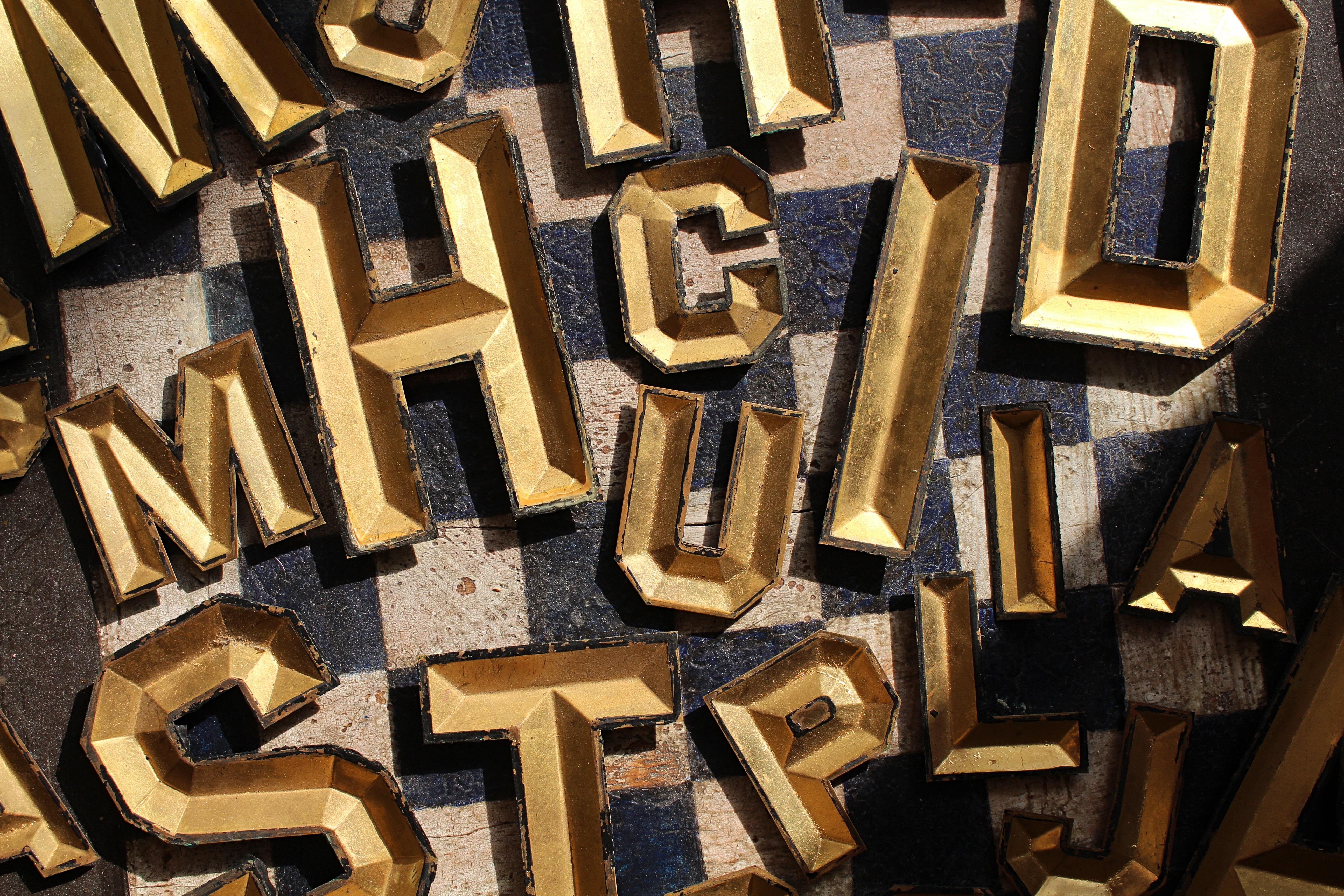 Early 20th Century large collection of pressed tin and gilt letters by the Radiant Letter Company New York available 

11 large letters, 23 smaller letters 

Large letters 