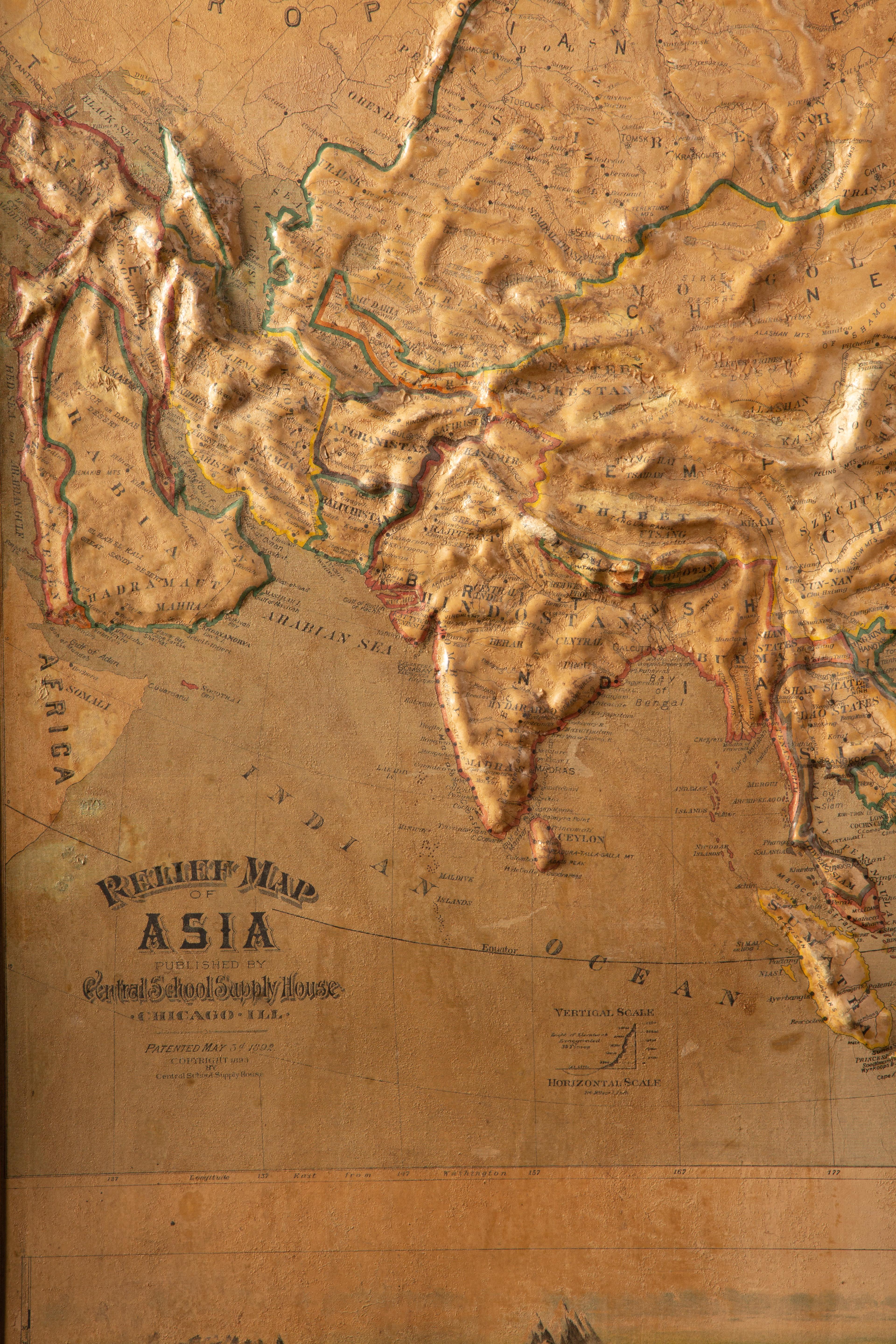 This early 20th-century set of three relief maps offers a captivating glimpse into the geographical features of South America, Asia, and Africa. The maps, meticulously crafted, are elevated by their presentation on a sturdy wood frame adorned with