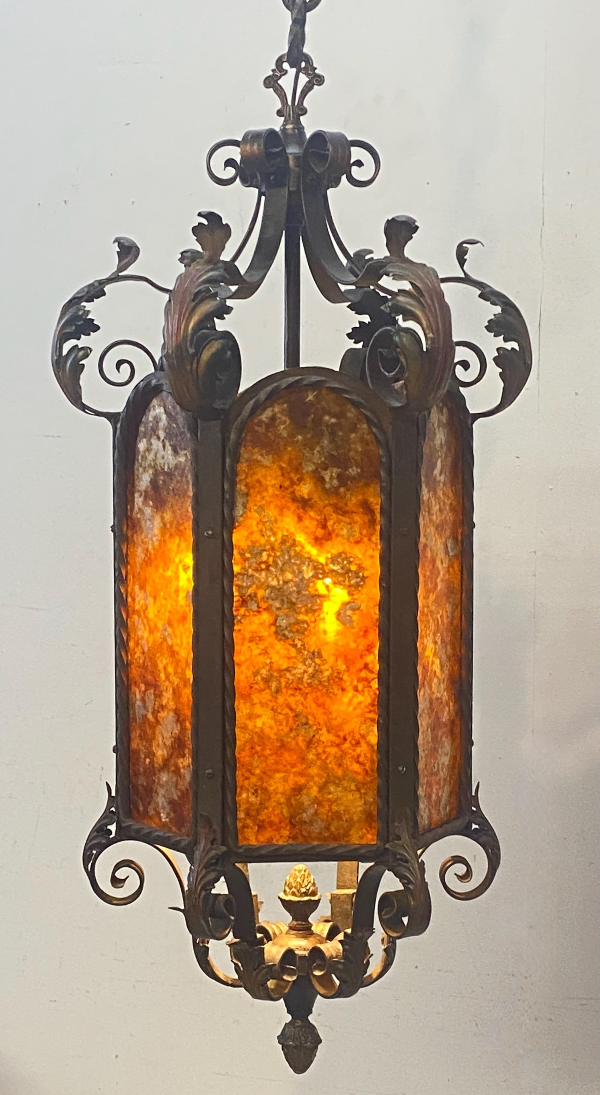 An exceptional antique wrought iron lantern with painted steel applied foliage and mica panels. Three light cluster, recently rewired and reconditioned. Ready to install.
Measurement of length with chain and canopy measures 58 inches. (We can