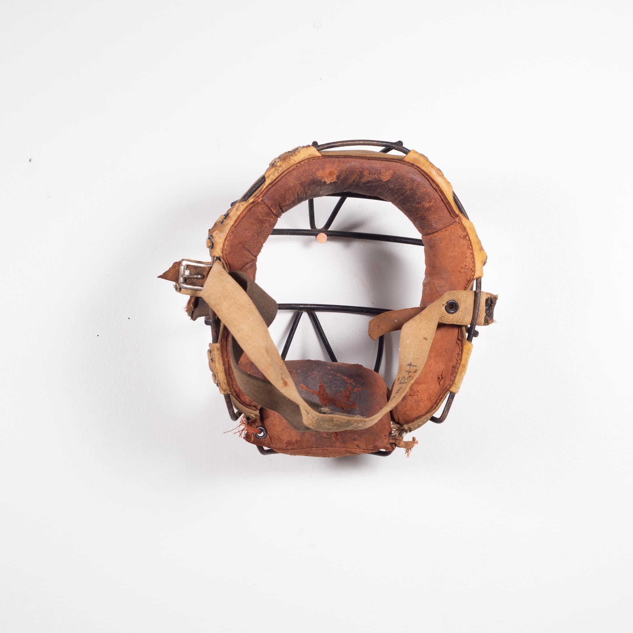 About

This is an original vintage catcher's mask. The main body is heavy steel with thick leather padding and fabric head strap. The padding is held onto the body of the mask by leather straps. Signed 