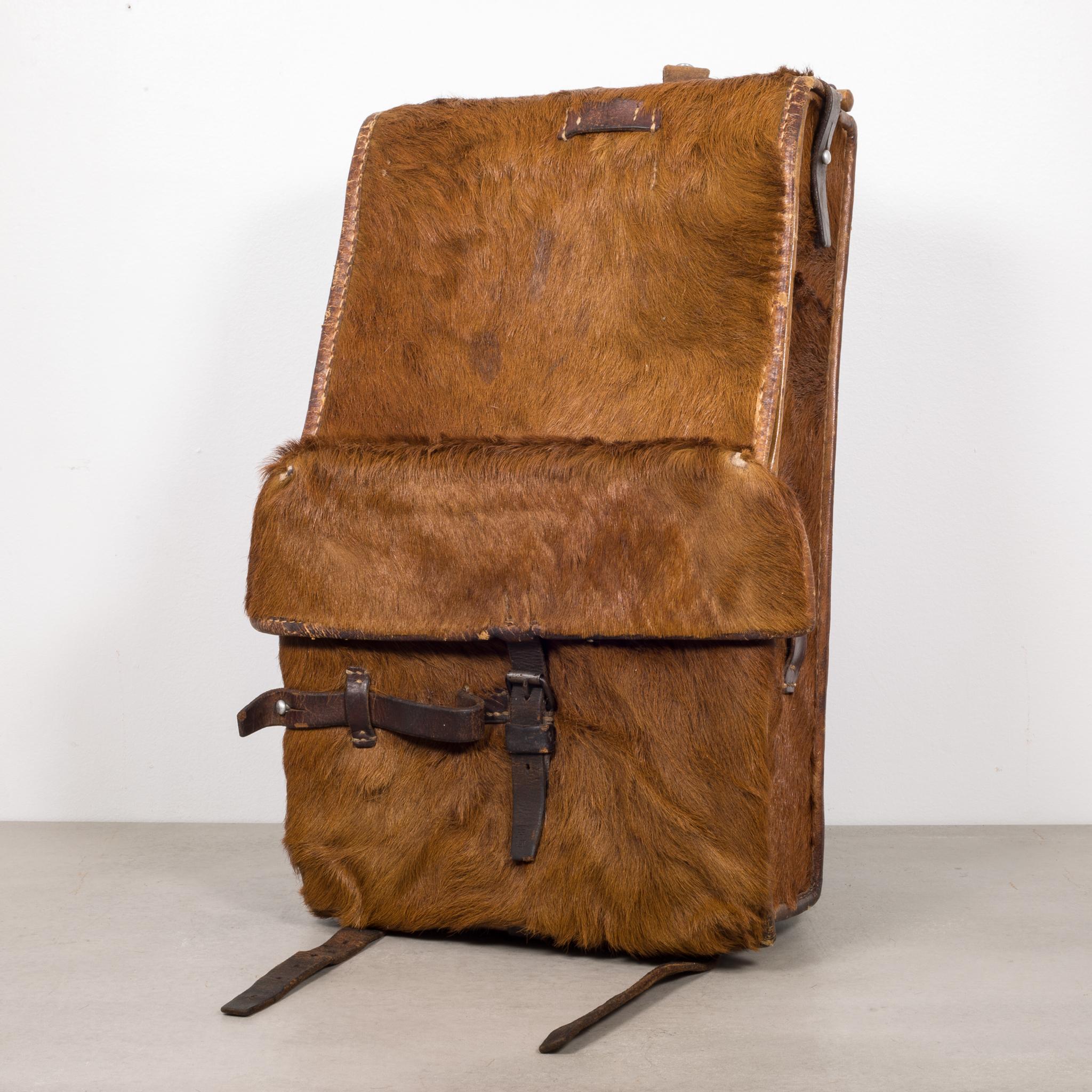 About

This is an original Swiss Army cowhide and leather backpack lined with fabric on the inside. The backpack has leather straps and buckles on the top, bottom, outside and inside. A wooden dowel runs through the leather on the top. There is a