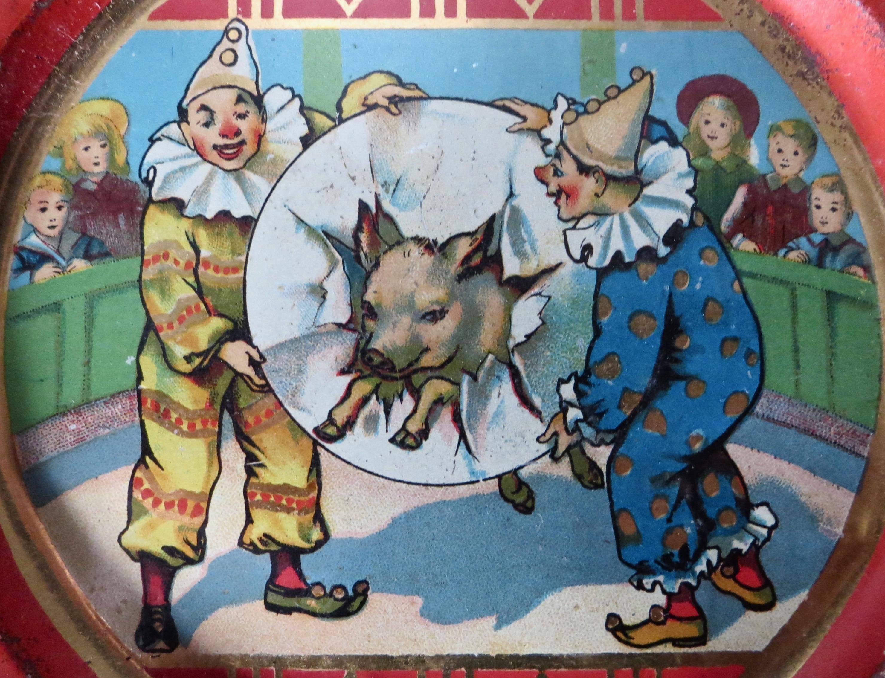 Saloon or soda fountain pressed steel tin tip tray; circa 1910 with whimsical theme showing a pig jumping through a paper covered hoop held by two colorfully dressed clowns, while spectators look on from behind the barrier. Excellent original