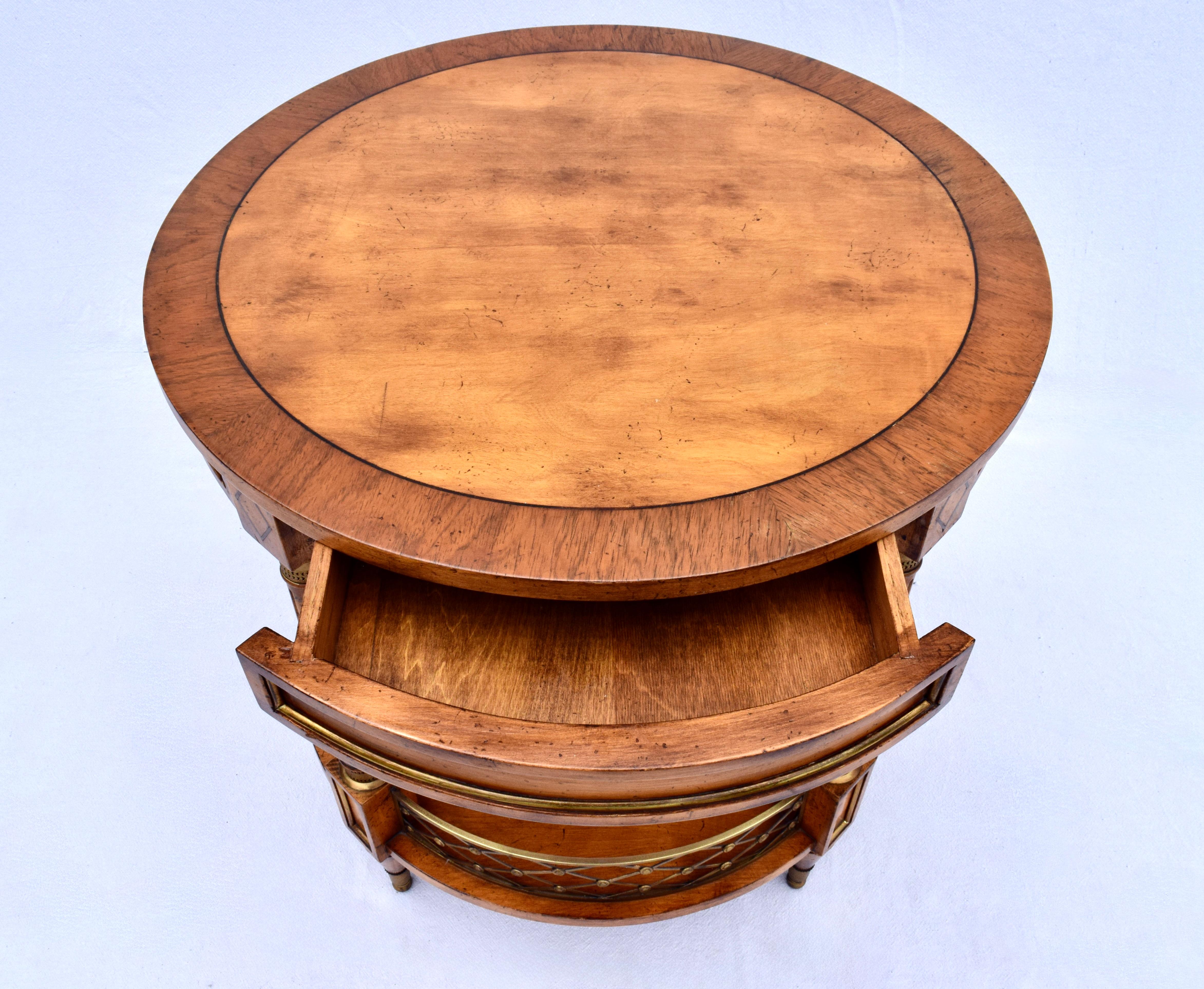 Tavolino o tavolino centrale in mogano a due piani in stile Regency con piano a fasce, cassetto a tasca nascosta con intarsi in legno incassati e decorazioni in ottone di ottima fattura. La galleria in ottone a reticolo, posta al livello inferiore,