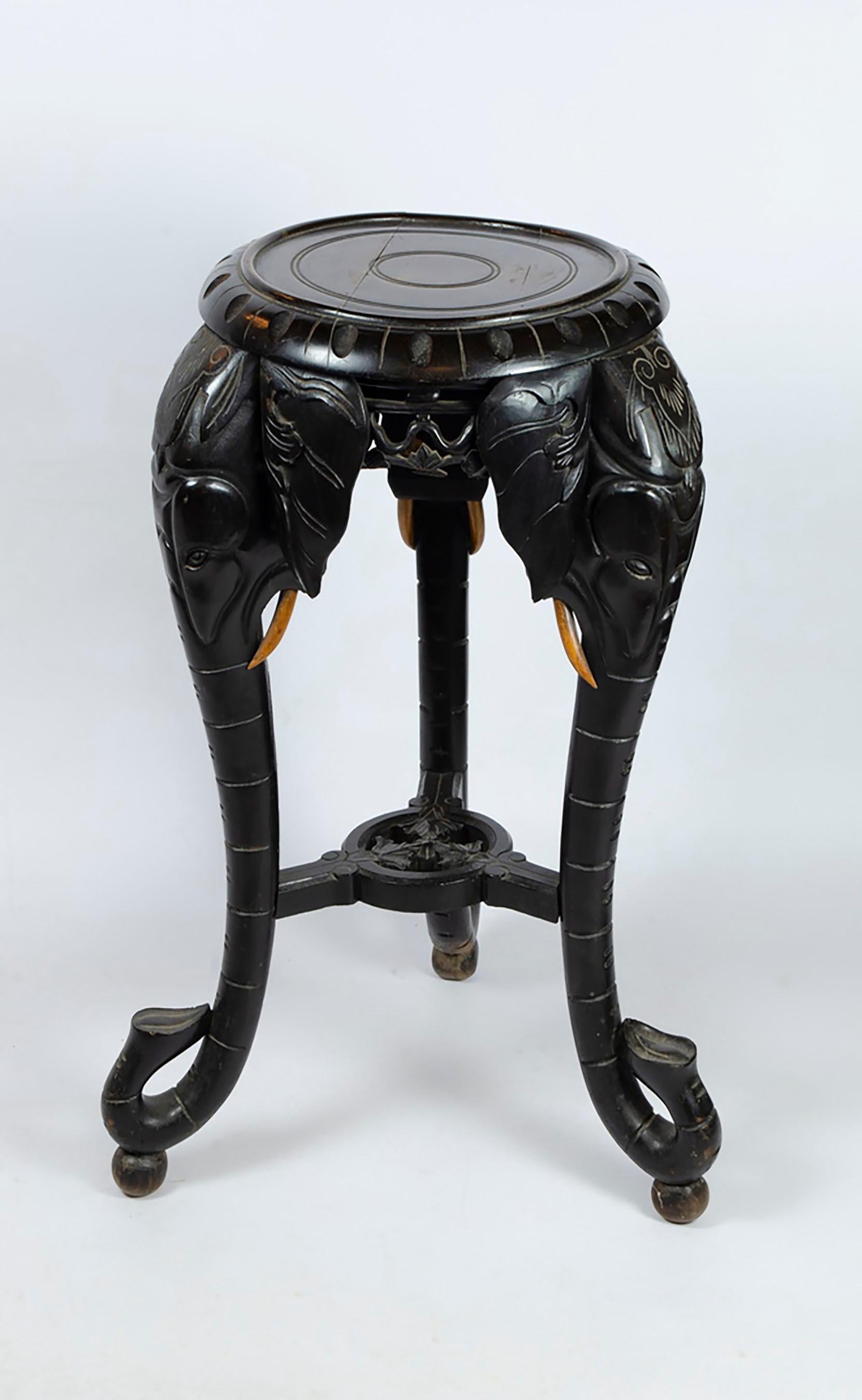 Ein Beistelltisch aus Hartholz aus dem frühen 20. Jahrhundert, handgeschnitzt mit schönen Elefantenköpfen/-stämmen, die die Beine des Tisches bilden. Ursprünglich in Südostasien geschnitzt, hat es eine schön gealterte ebonisierte Färbung mit der