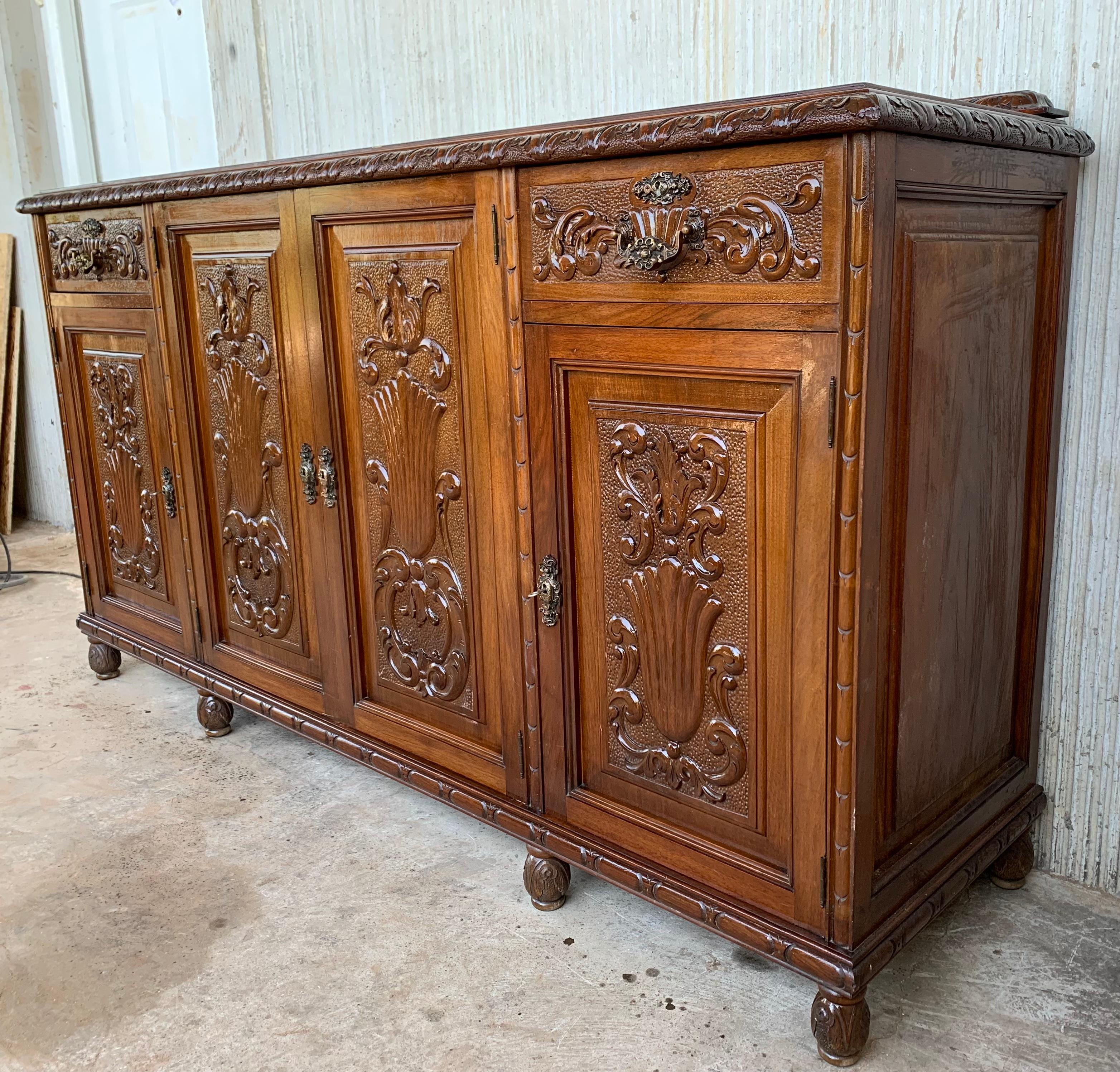 Spanish Early 20th Carved Walnut Sideboard with Four Doors and Two Drawers and Crest For Sale