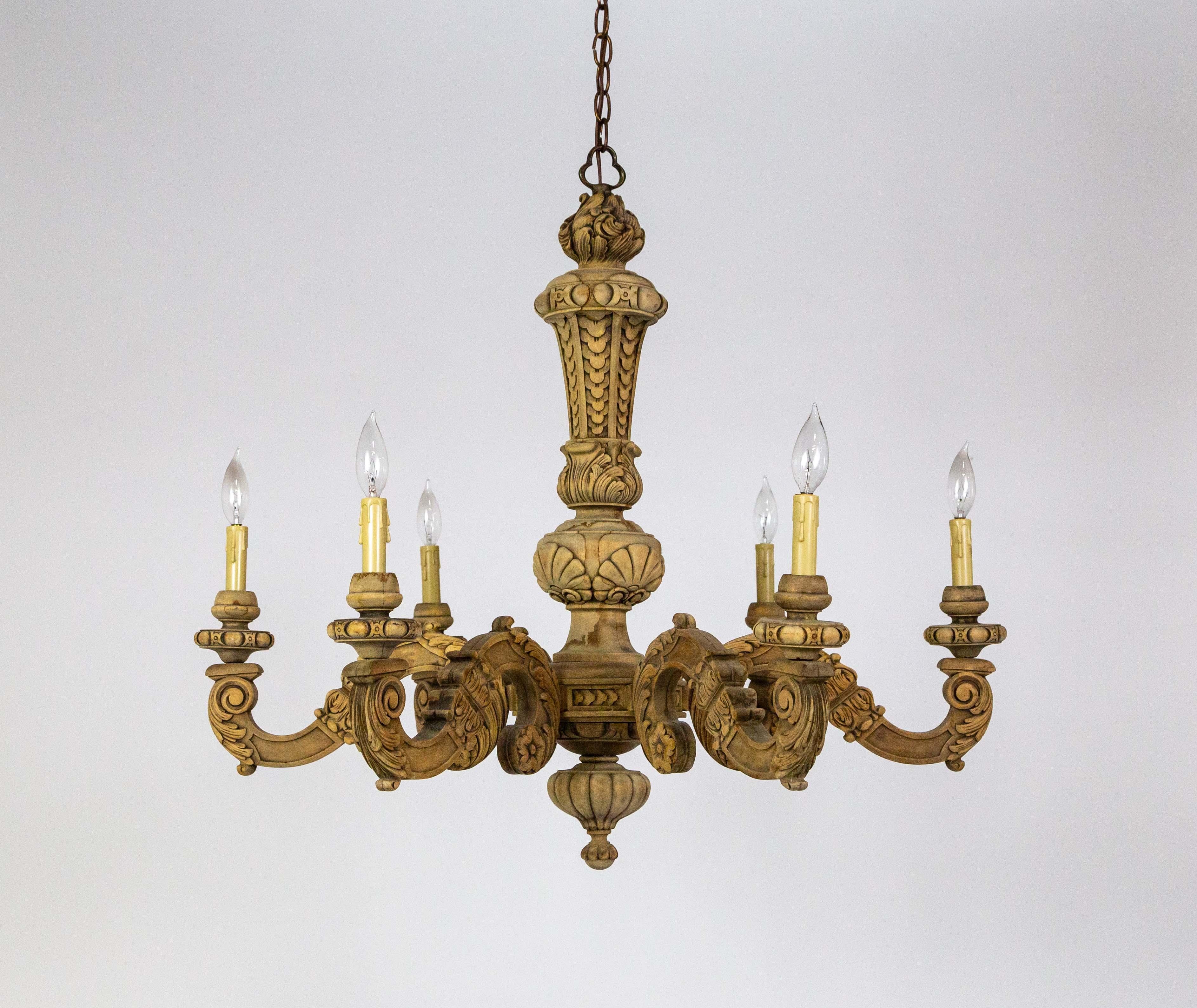 A raw wood chandelier with 6 S-curved, candlestick arms expertly carved with clean lines and structure. The motif includes egg-and-dart bobeches, acanthus leaves, florets, shells, and a gadrooned bottom finial. Circa 1920.  Newly rewired with a 48