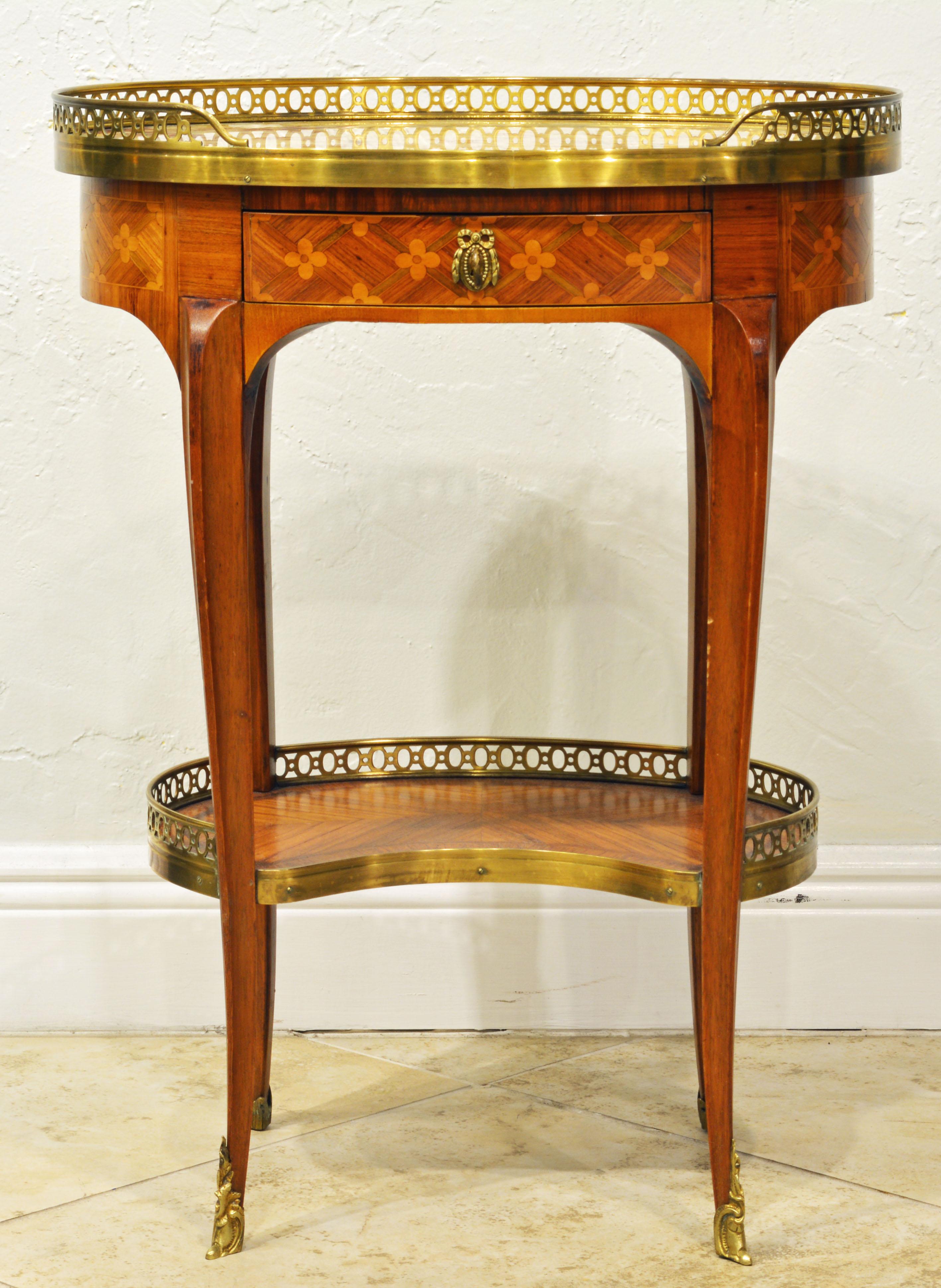 Raised on four shapely cabriole legs with bronze sabots this elegant table in the Louis XV style features a marble top partly surrounded by an intricately pierced bronze gallery above one frieze drawer and a lower similar gallery tier. The surfaces