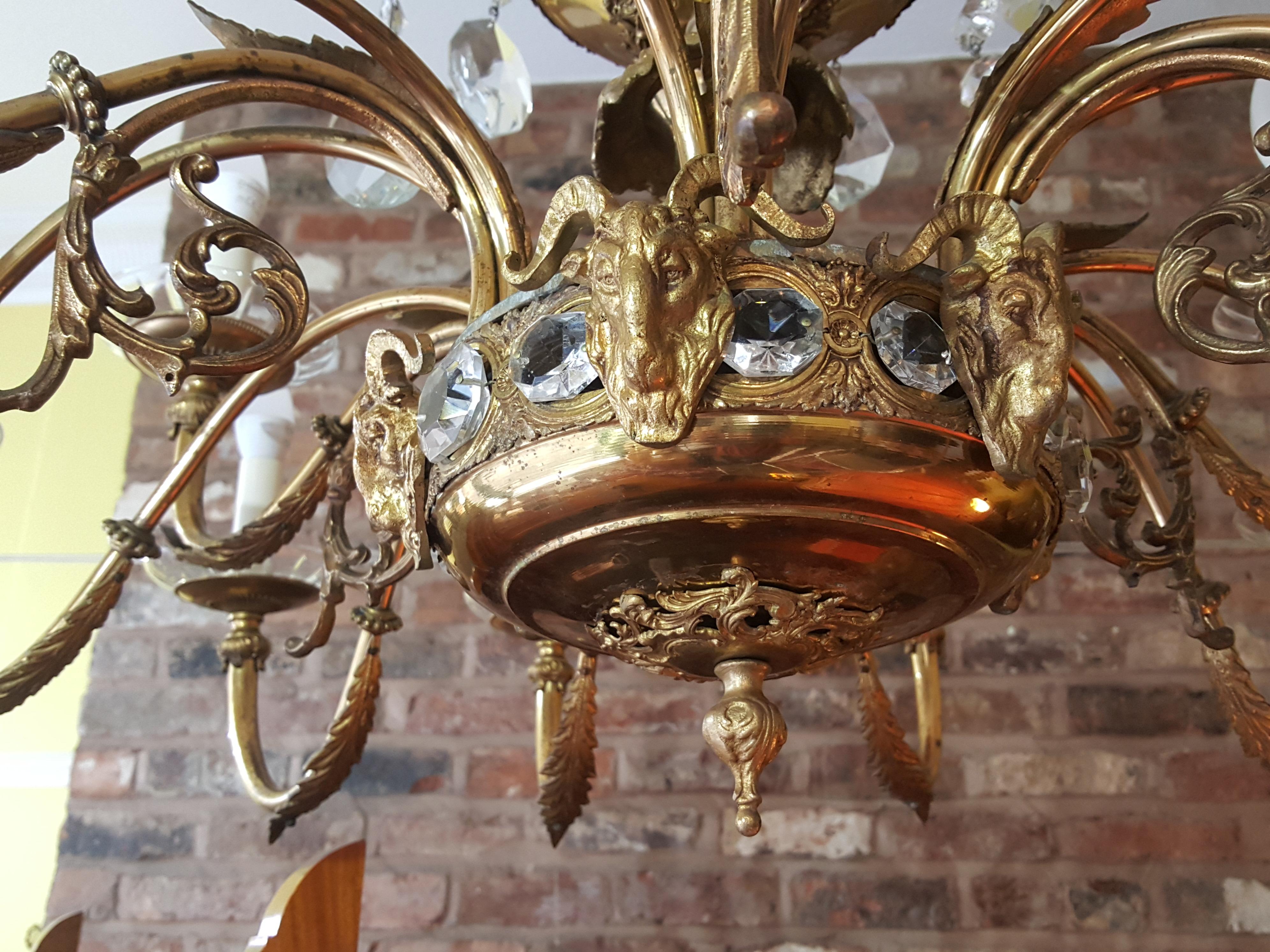 Early 20th century 18 light brass and crystal chandelier with Adam style ram’s head, rosette, and crystal decorations - all lights have been rewired and pat tested
Measures: 40