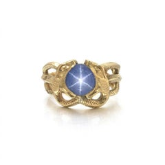 Bague « double serpent » en or 18 carats sertie d'un saphir étoilé de Ceylan, début du XXe siècle