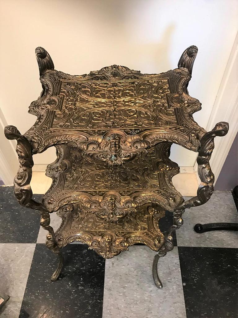 Interesting antique brass 3-tier table. Can be used as a pedestal to hold a plant or sculpture. Would also be a great accent piece in a corner holding a lamp. The height of the space between each shelf is 9.5
