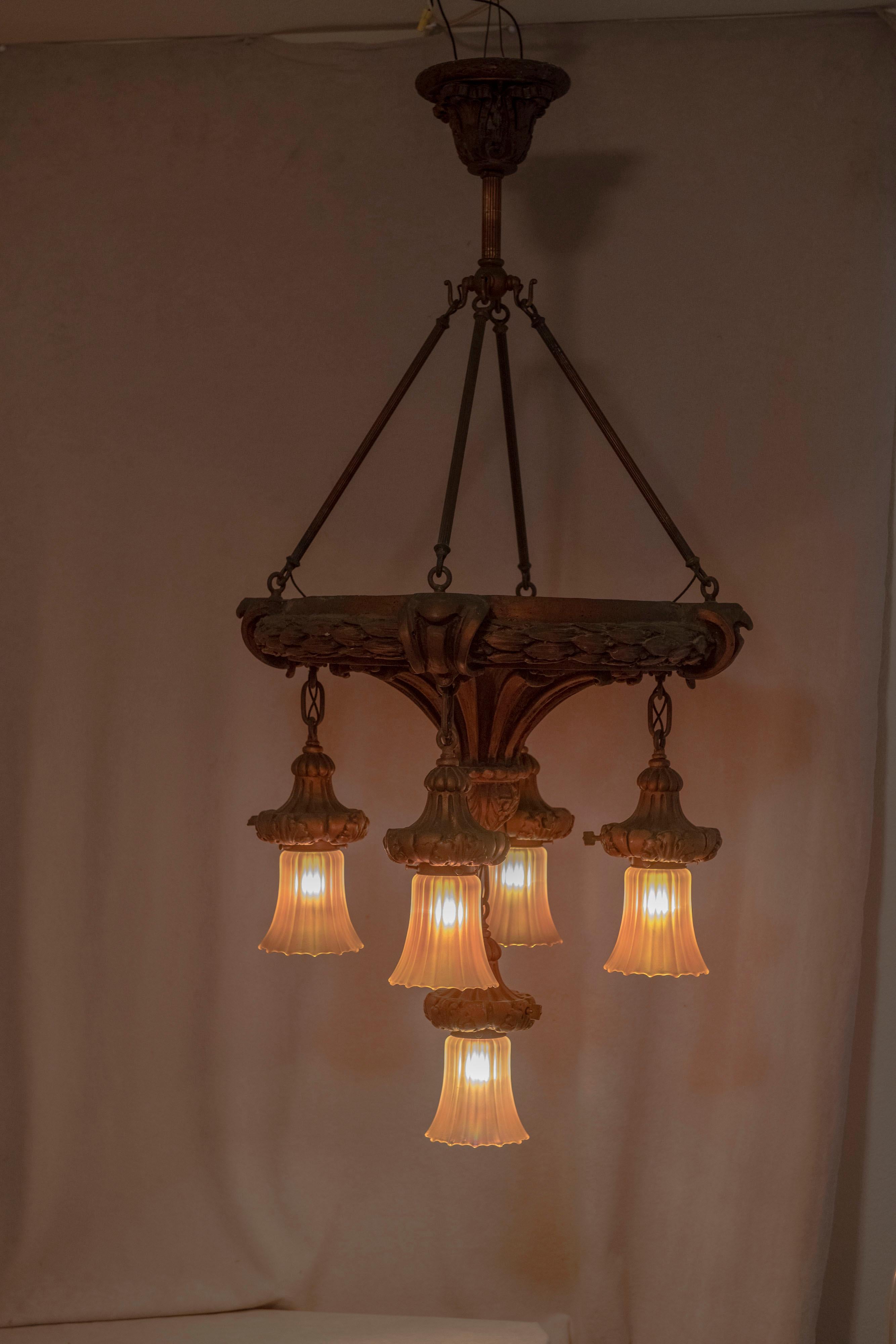   Lustre très orné et inhabituel en gesso avec 5 abat-jours de carnaval d'époque par Nuart. Le corps a été coulé dans du gesso puis pigmenté à l'or. L'or s'est assombri gracieusement et uniformément au fil des ans. aPas la qualité des pièces
