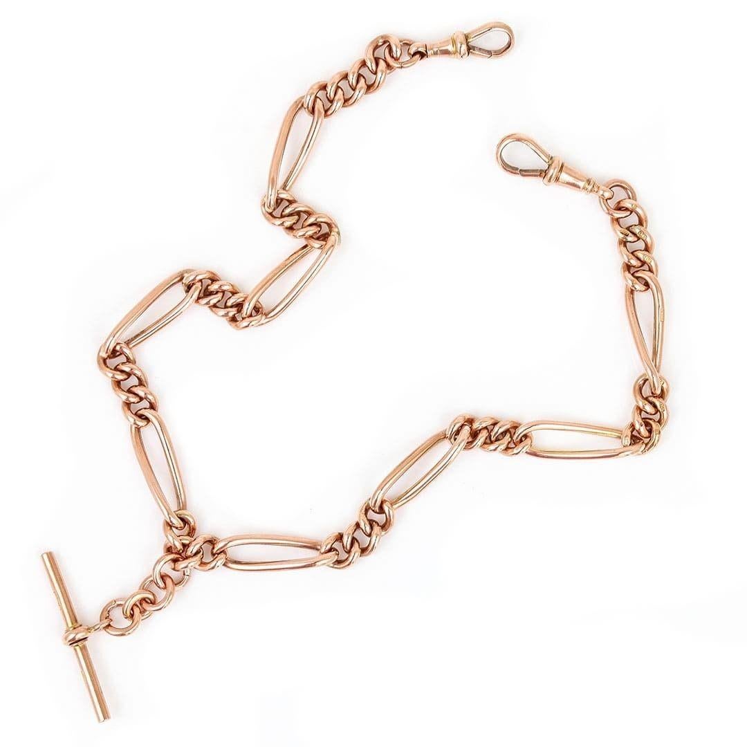A solid, 9ct rose gold antique early 20th century Albert chain with alternating curved trombone and round uniform links with a T-bar. Every link is stamped ‘9' '375', the two swivel clips and t-bar are also marked along with the makers mark. The
