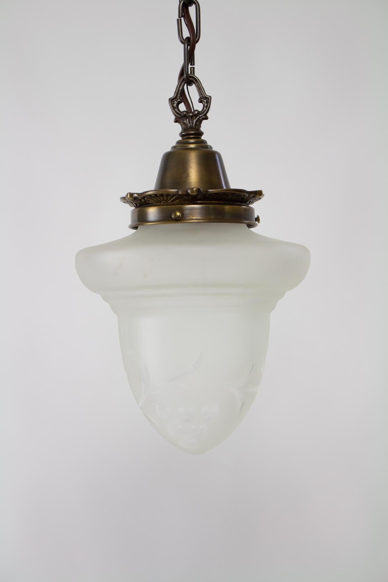 Early 20th Century acorn glass pendant. Custom new pendant in solid brass. Glass is frosted with a cut glass colonial revival grape pattern. Glass in very good condition, with light marking due to the age. Single Edison base socket, 100 Watt max.