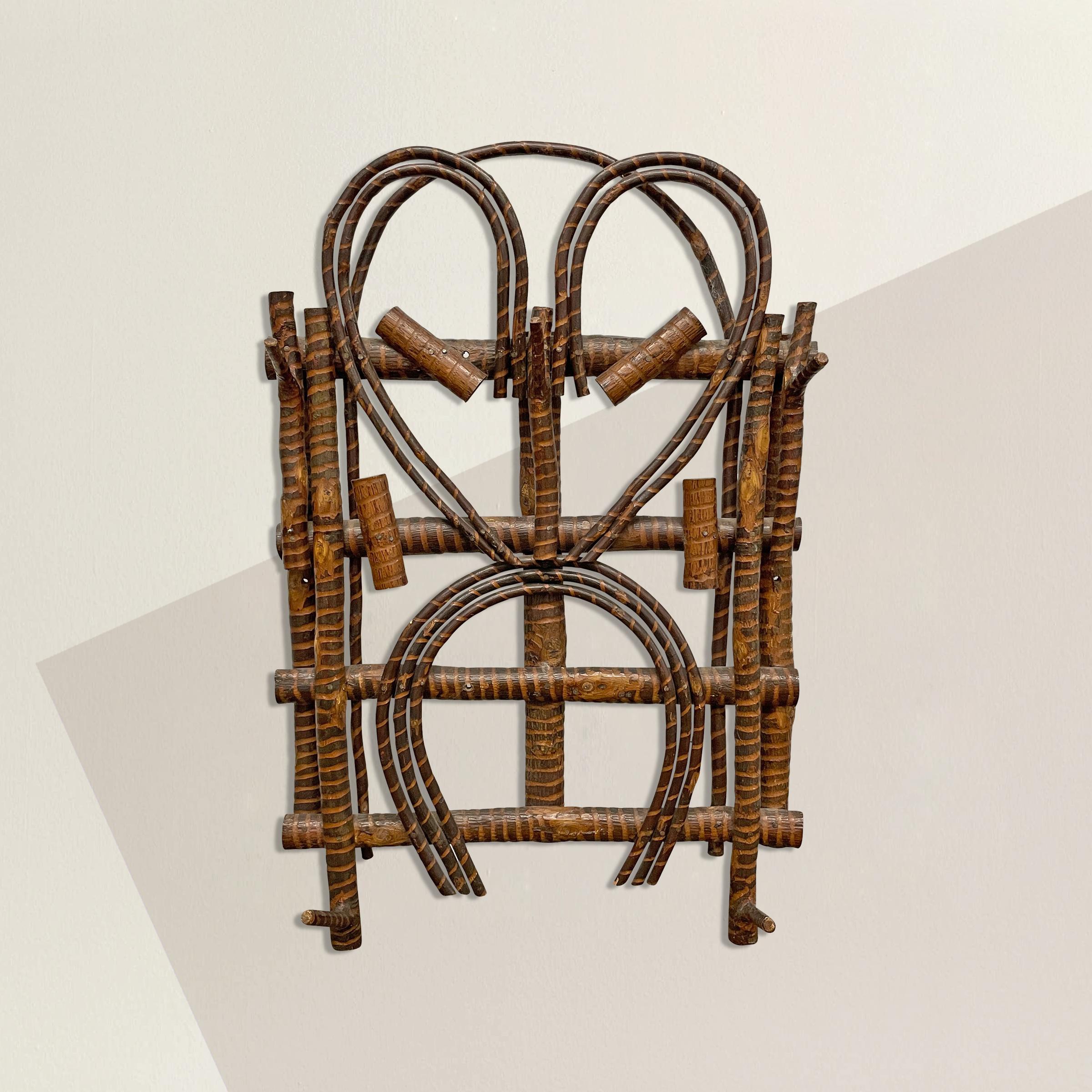 A quaint early 20th century American Adirondack bent and carved willow branch coat and hat rack with a heart and horseshoe motif, two hooks on each side, and one hook in the center at the top.