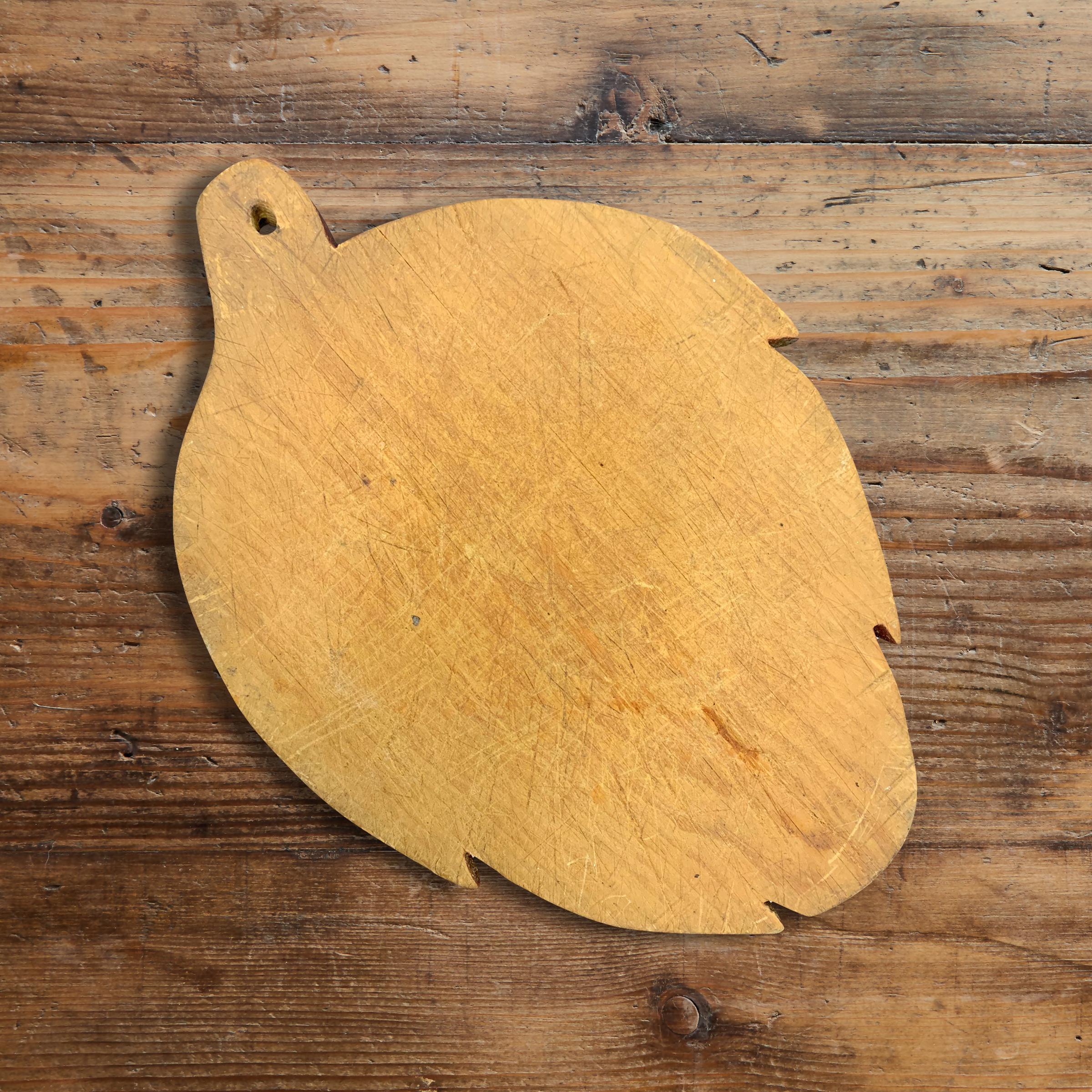 A whimsical early 20th century American pine artichoke-form cutting board with a red painted edge. Perfect for serving charcuterie and cheese at your next cocktail party, and works beautifully as a cutting board on your kitchen counter.