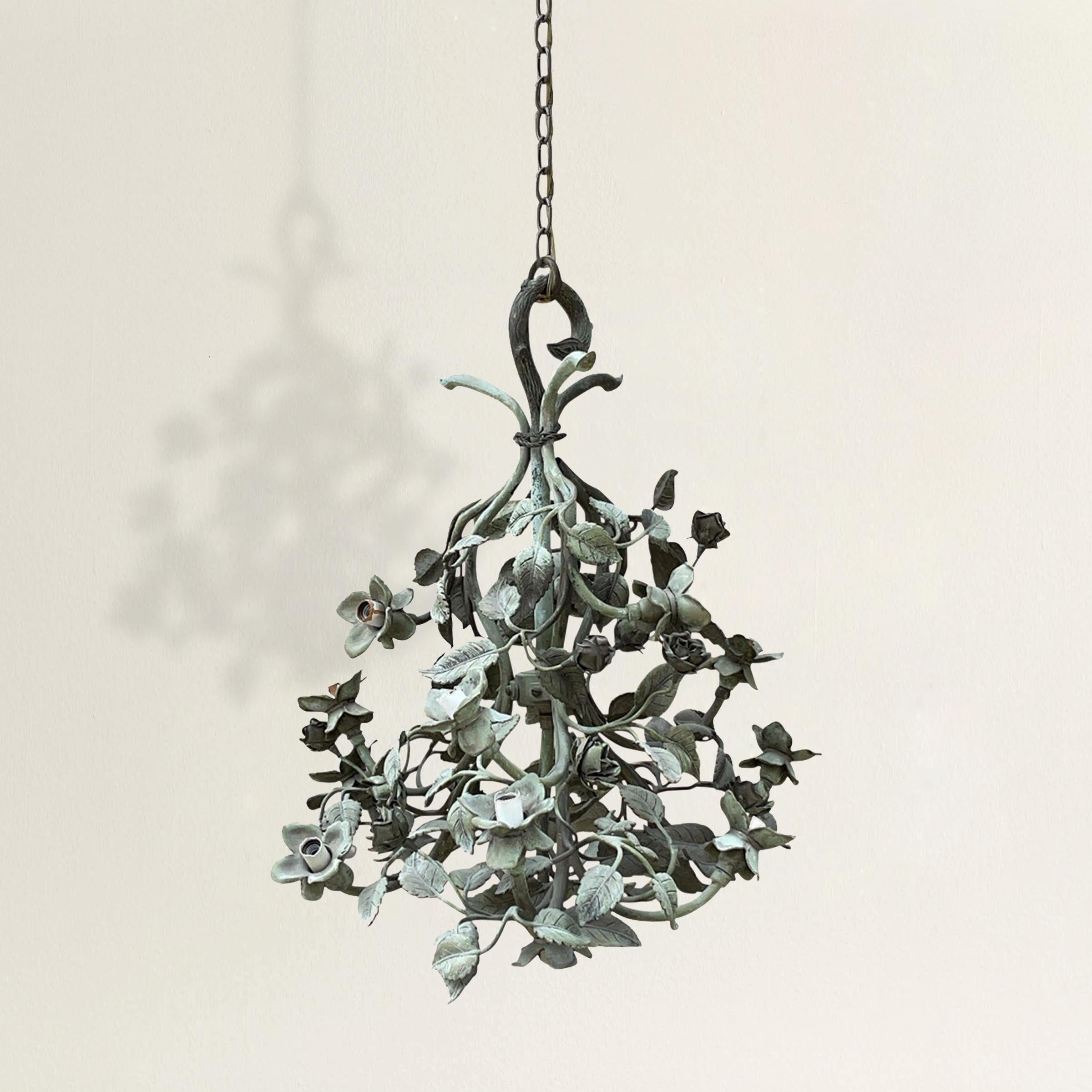 A charming and romantic early 20th century American cast bronze 'Secret Garden' chandelier built with three climbing rose branches joined at the top with a faux bois hook, and twelve lights throughout the cluster and one in the center at the bottom.