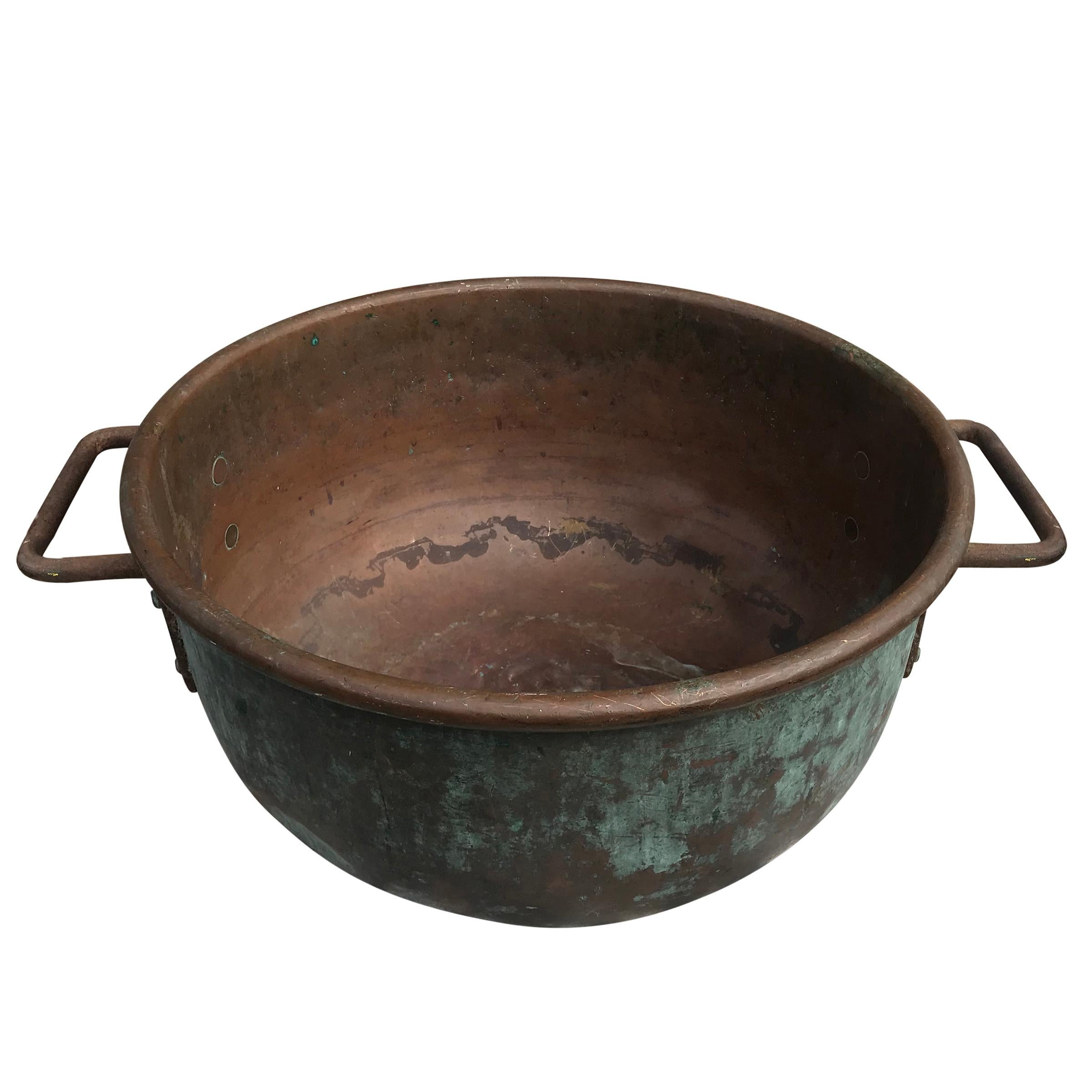 A wonderfully patinated early 20th century American hammered copper confectioner's pot used in the candy and chocolate making process, with iron handles attached with hammered copper rivets, and a lovely patina only copper and time can bestow. There