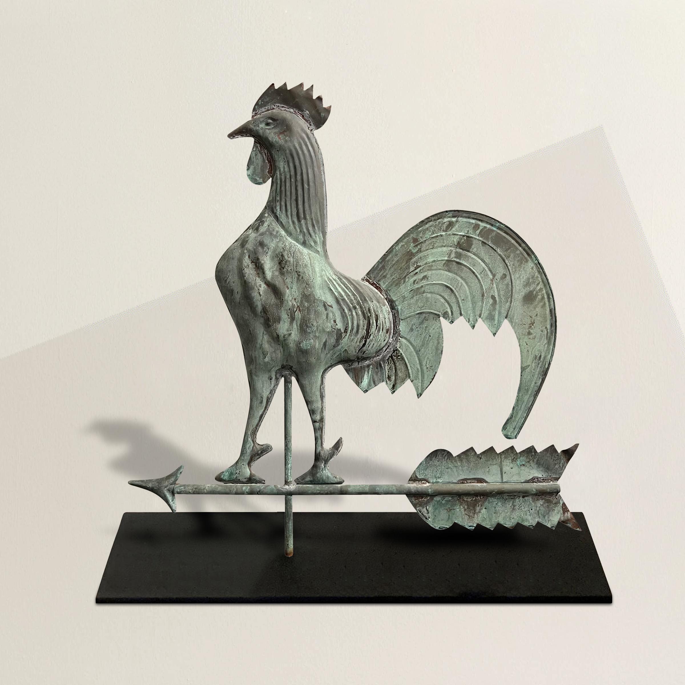 Behold the captivating presence of an early 20th-century American copper folk art rooster weathervane, a charming and iconic symbol of traditional craftsmanship. This delightful weathervane showcases a dimensionally sculpted hollow body, complete