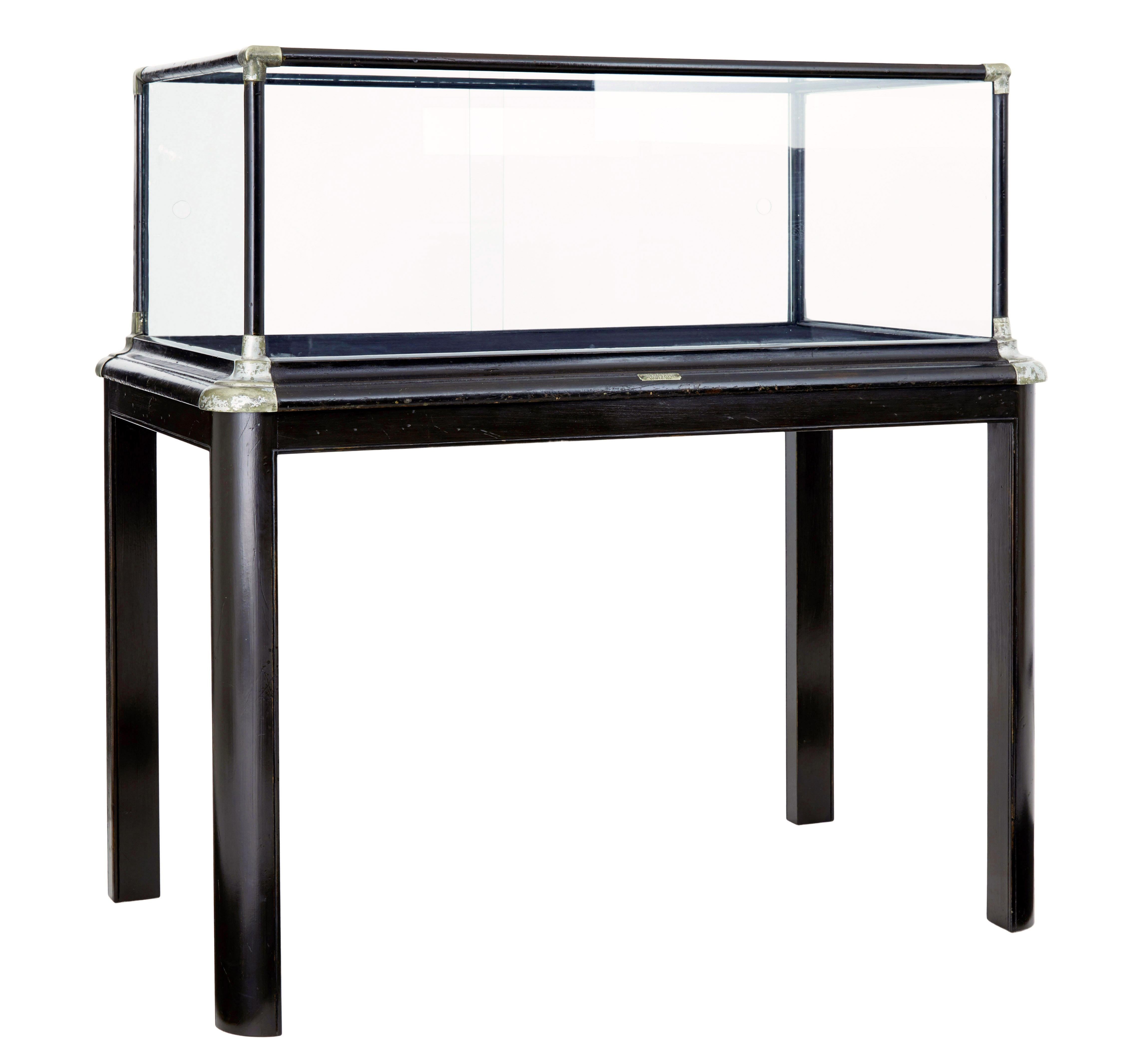 Early 20th century American display cabinet by quincy showcase works illinois circa 1900.

Fine quality piece by well known cabinet makers quincy showcase works.  Shaped plinth base with decorative metal mounts supporting the glazed display area. 