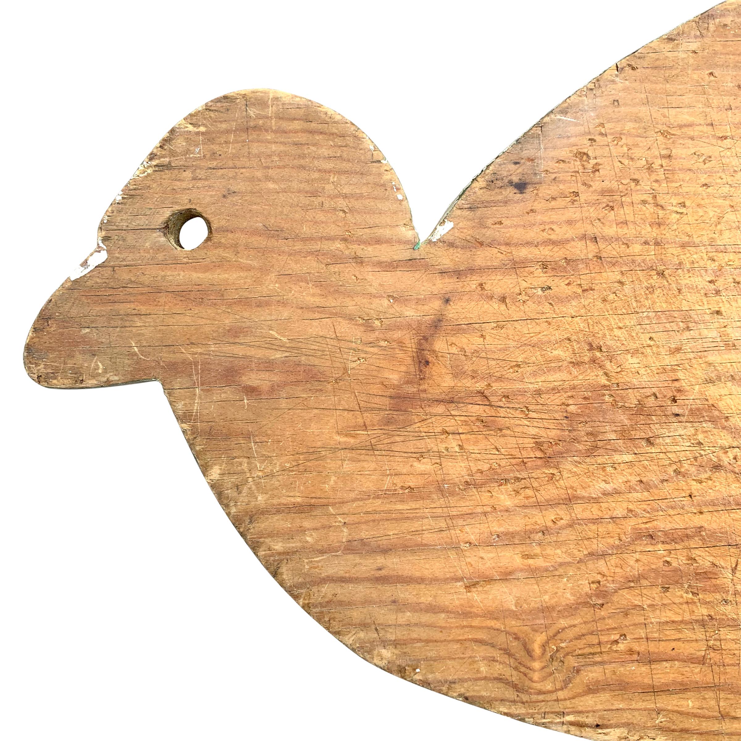 A whimsical early 20th century American pine cutting board in the form of a duck, with a white painted edge. Perfect for serving cheese or charcuterie at your next party.