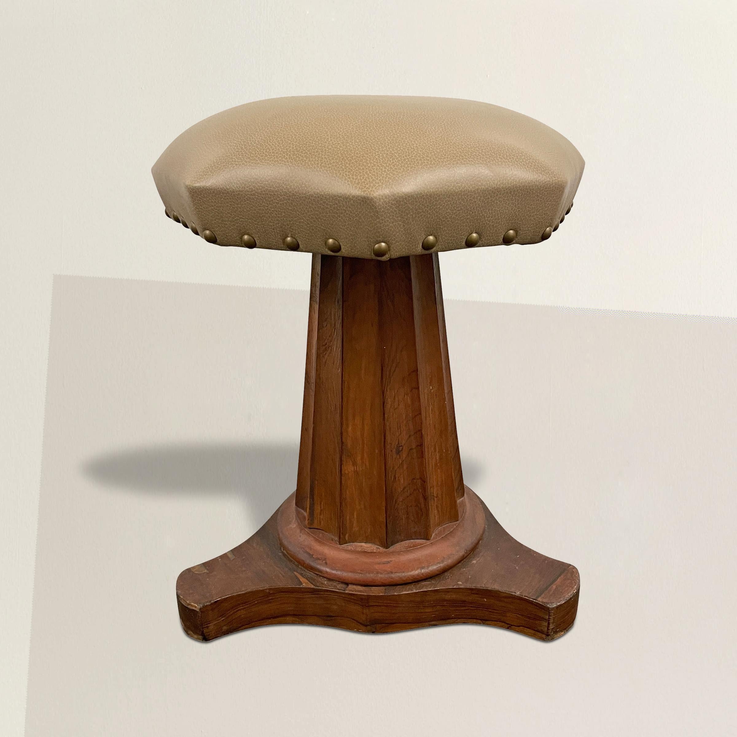 A charming and handsome early 19th century American Empire mahogany stool with a tapered fluted Doric column supported by a flat three legged base, and an octagonal seat with a gray leather upholstery and nail head trim. Perfect for extra seating in