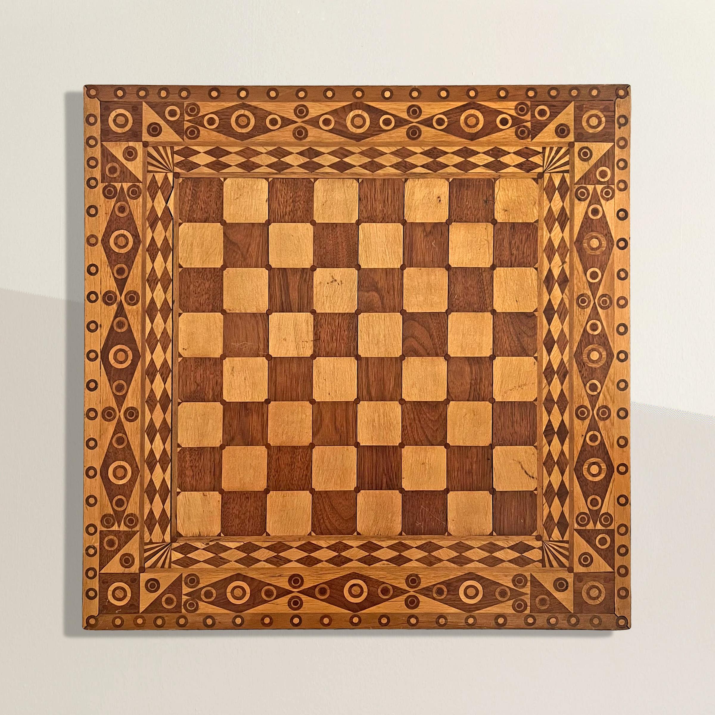 Prepare to be captivated by this extraordinary early 20th century American Folk Art game board, a true marvel of craftsmanship and creativity. Constructed meticulously from a staggering 1,226 geometric patterned inlaid oak and maple wood pieces,