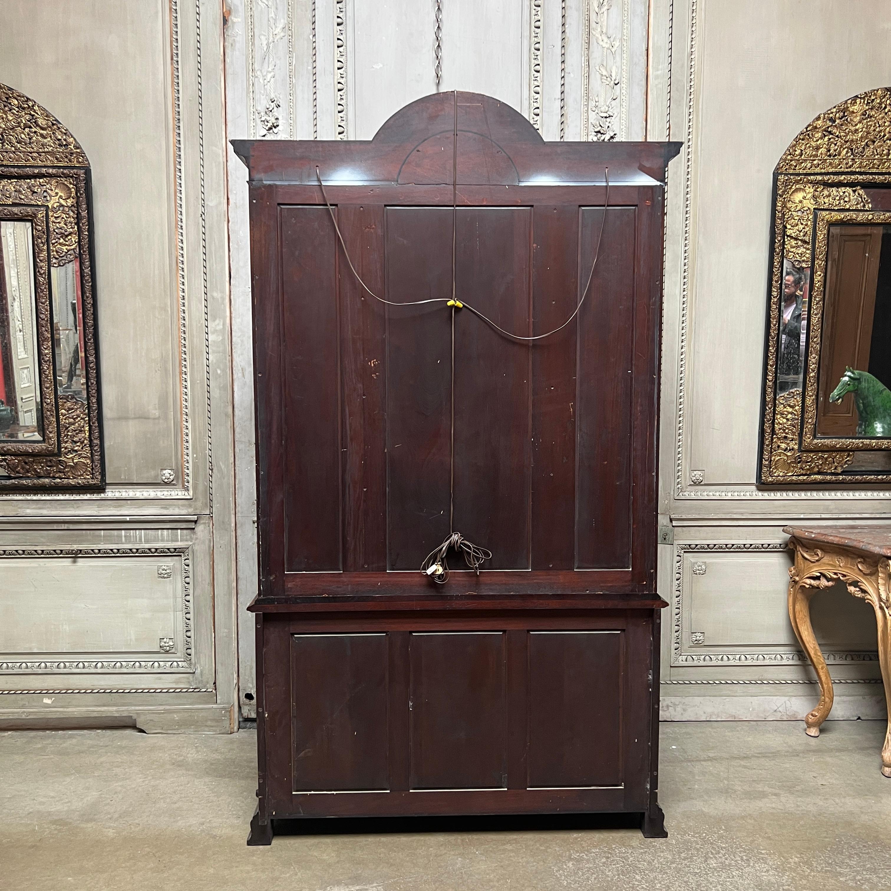 A fine quality American made George II style bookcase, breakfront, china cabinet in mahongay with inayed boxwood. This piece has a glass upper section with glass shelves and an arched top, It is nicely detailed throughout and is a wonderful smaller