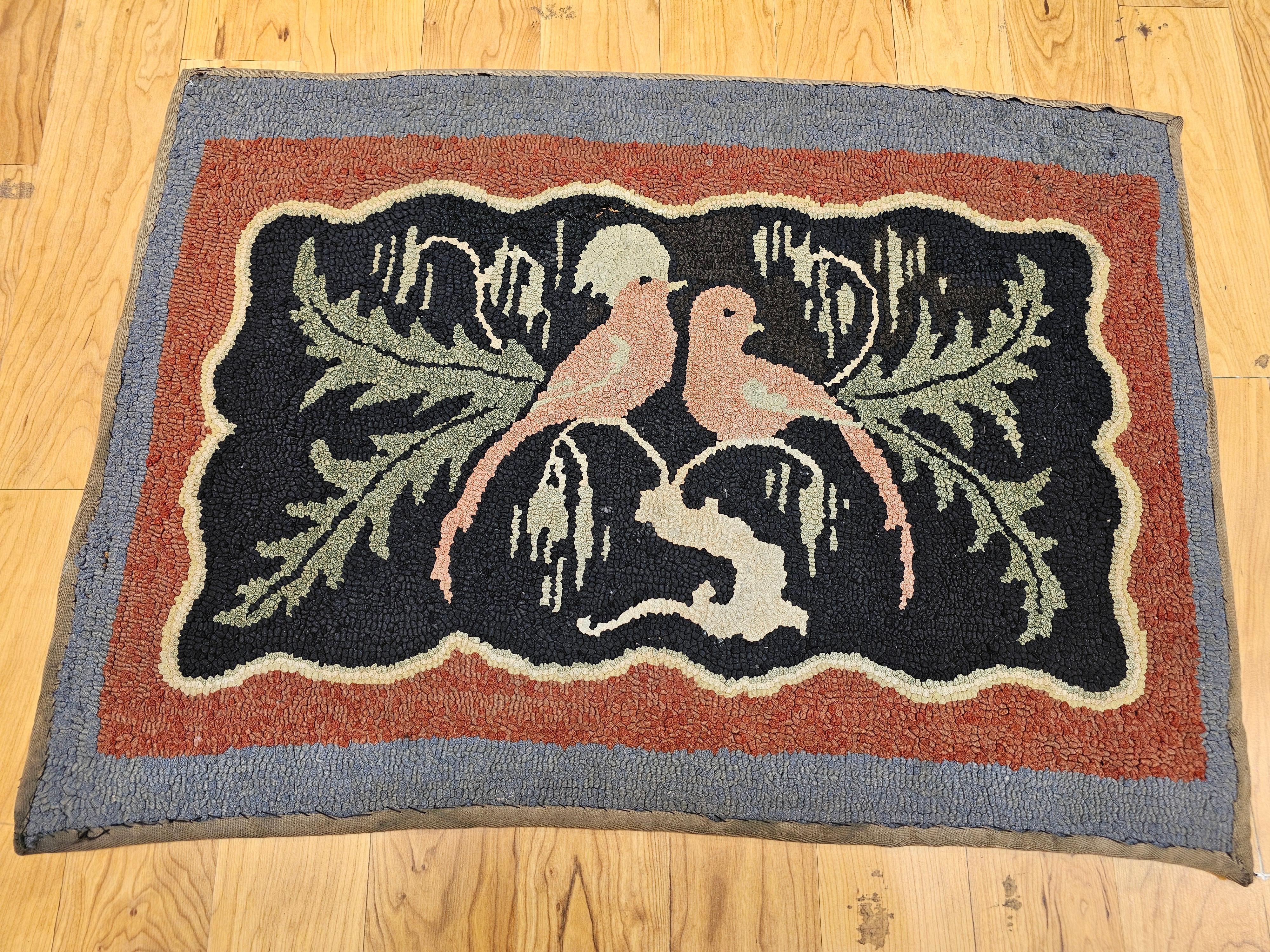 A charming and whimsical example of early American textile folk art, this hand-hooked rug from the early 20th century beautifully depicts a pair of lovebirds perched on a tree branch. Rendered in a delightful palette of ivory, lavender pink, forest