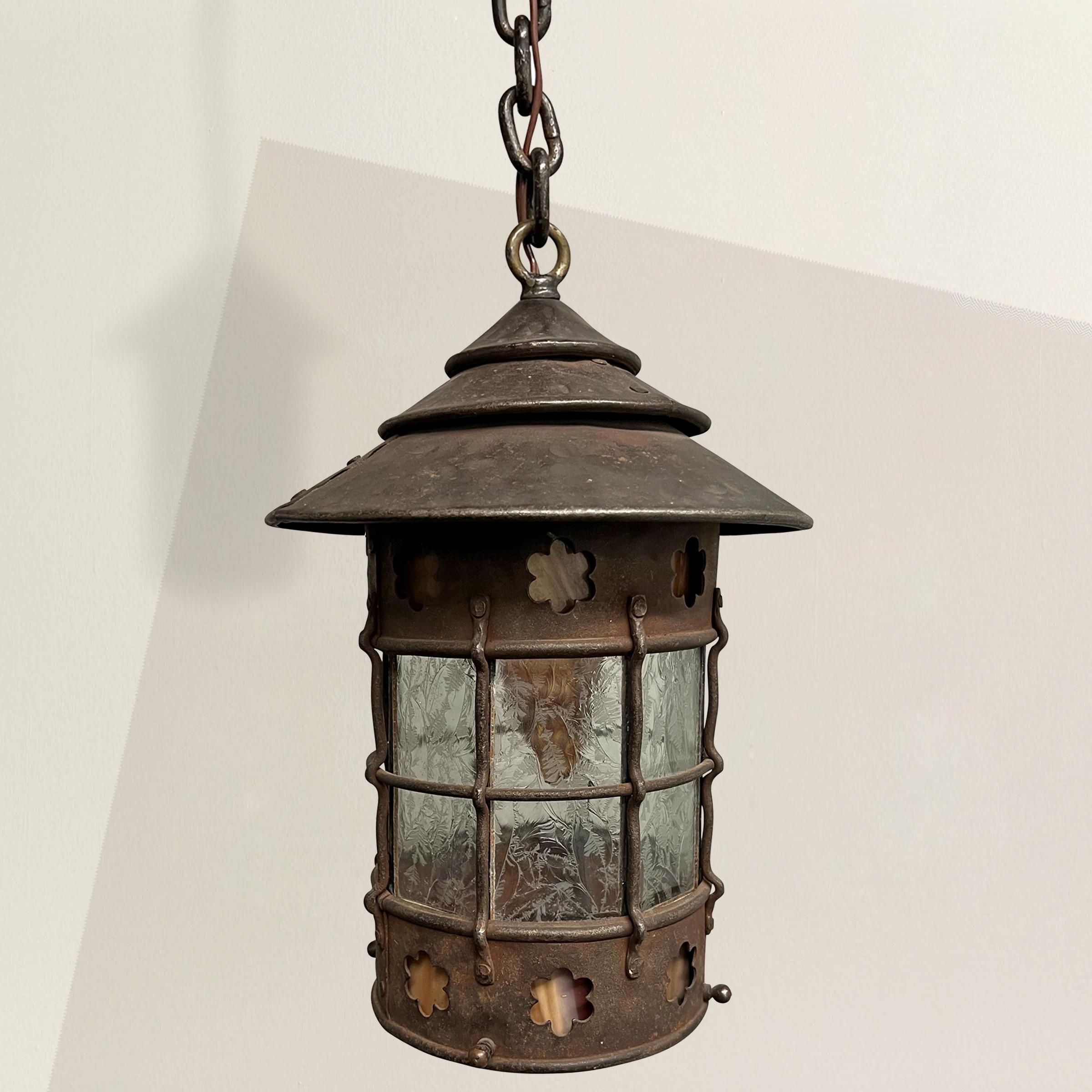 Indulge in the timeless beauty of the early 20th-century American Arts and Crafts movement with this exquisite hand-wrought iron lantern. This exceptional piece showcases the hallmark characteristics of the movement, known for its emphasis on