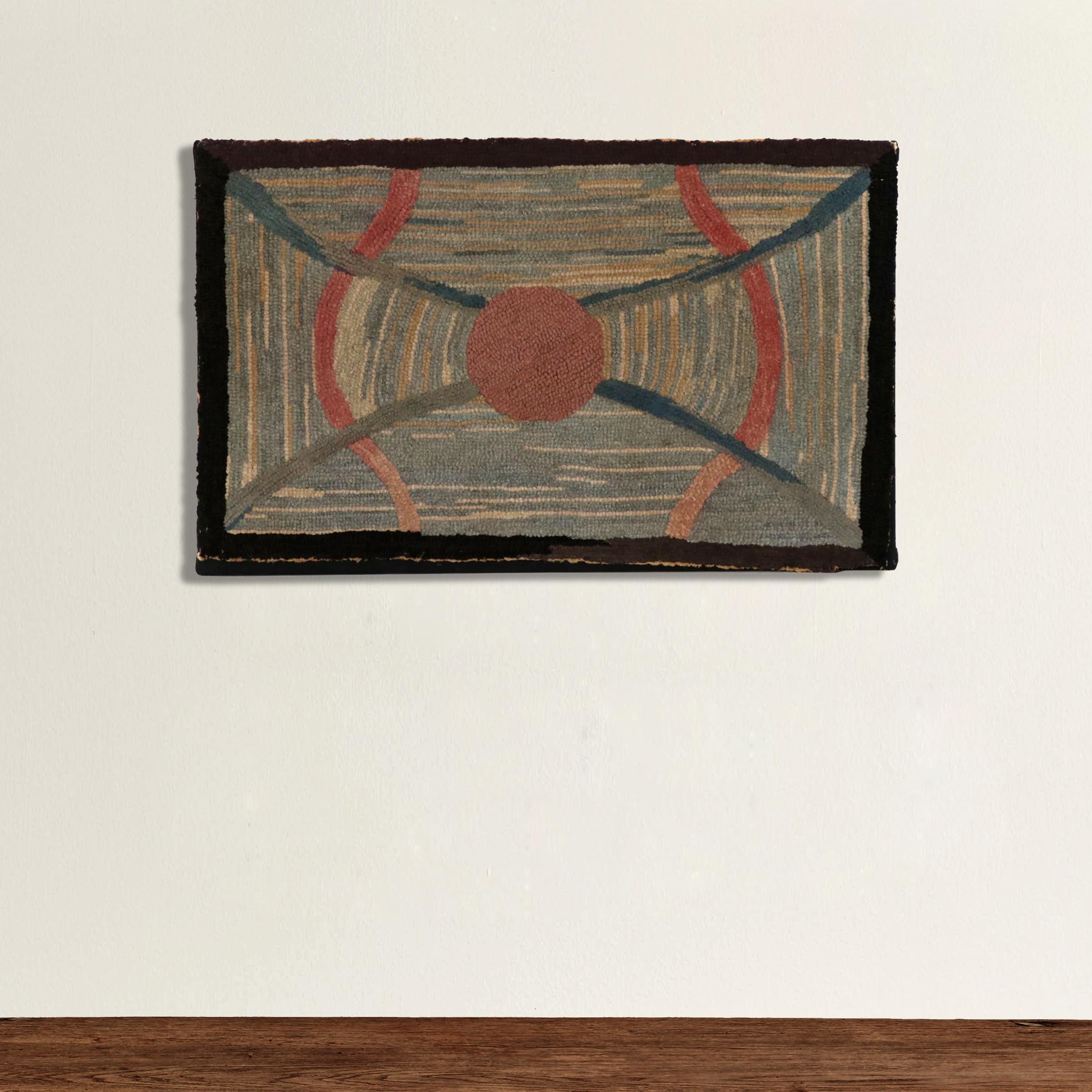 A charming early 20th century American hook rug with a wonderfully abstract pattern containing a large red circle in the center with pairs of red and blue curved lines against a variegated background. Mounted to a black linen stretched canvas.