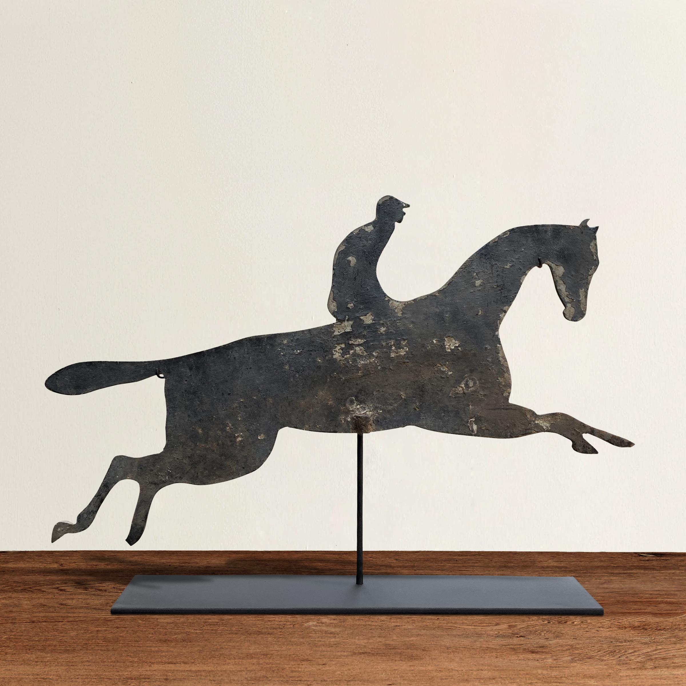 A fun and whimsical early 20th century American aluminum horse and jockey silhouette weathervane mounted on custom steel stand. Traces of original gray paint remain.