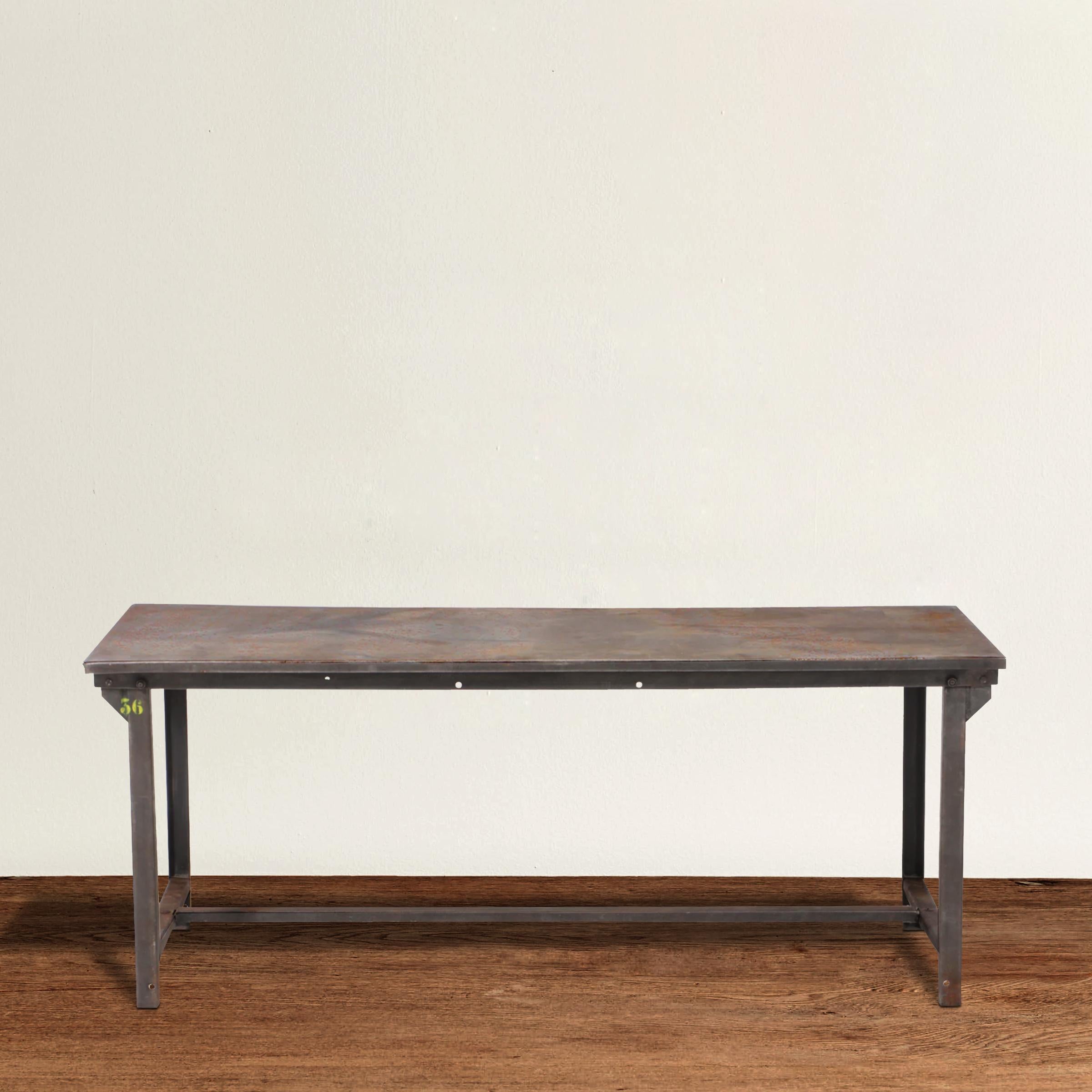 A wonderful and strong early 20th century American industrial steel work table with straight legs, a simple steel stretchers running between each pair of legs, and single piece of steel on top. Table can easily seat six people comfortably, or eight