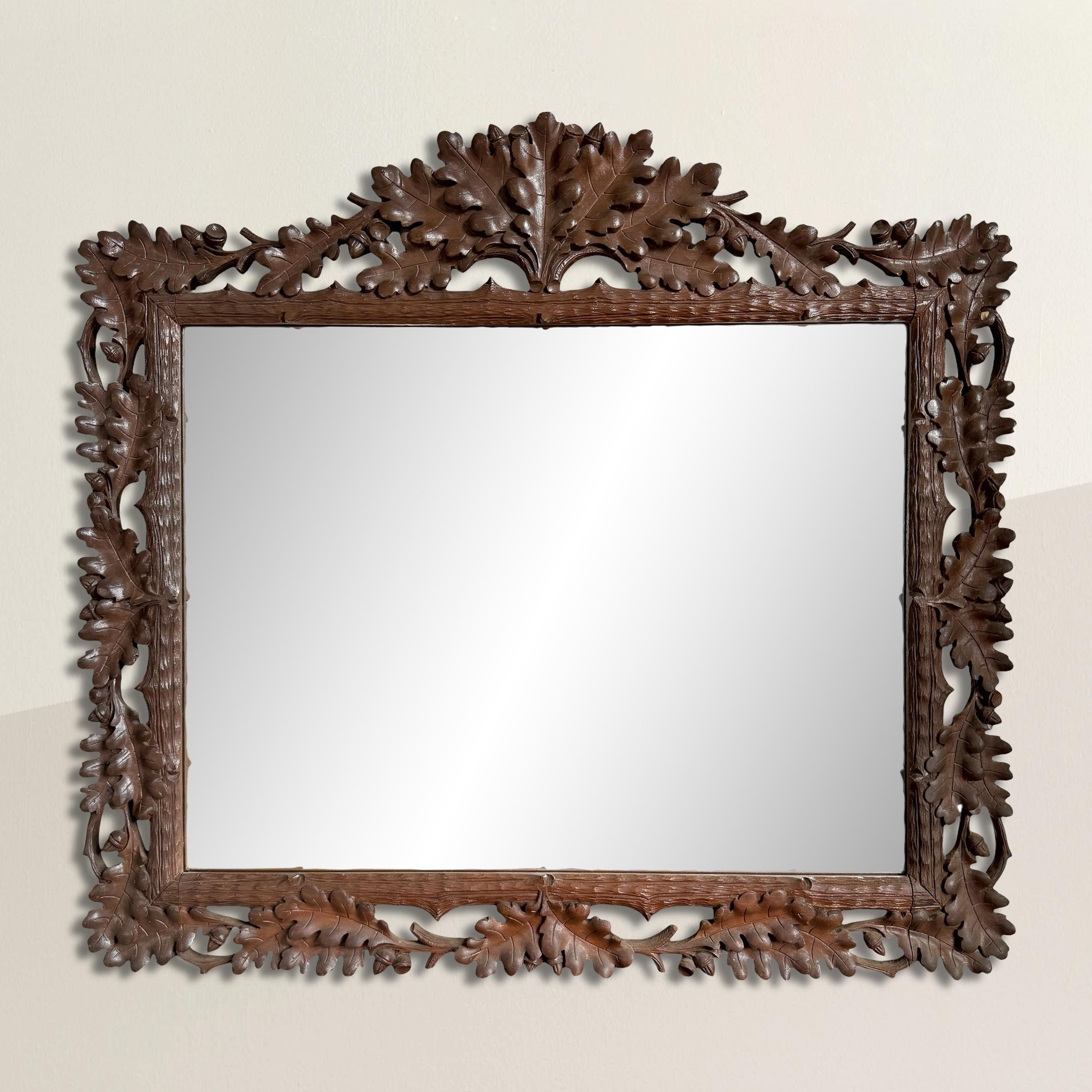 A striking example of early 20th-century Swiss craftsmanship, this hand-carved wooden mirror draws inspiration from the rich traditions of Black Forest carving. Originating in the Alpine regions of Germany and Switzerland, Black Forest artisans were